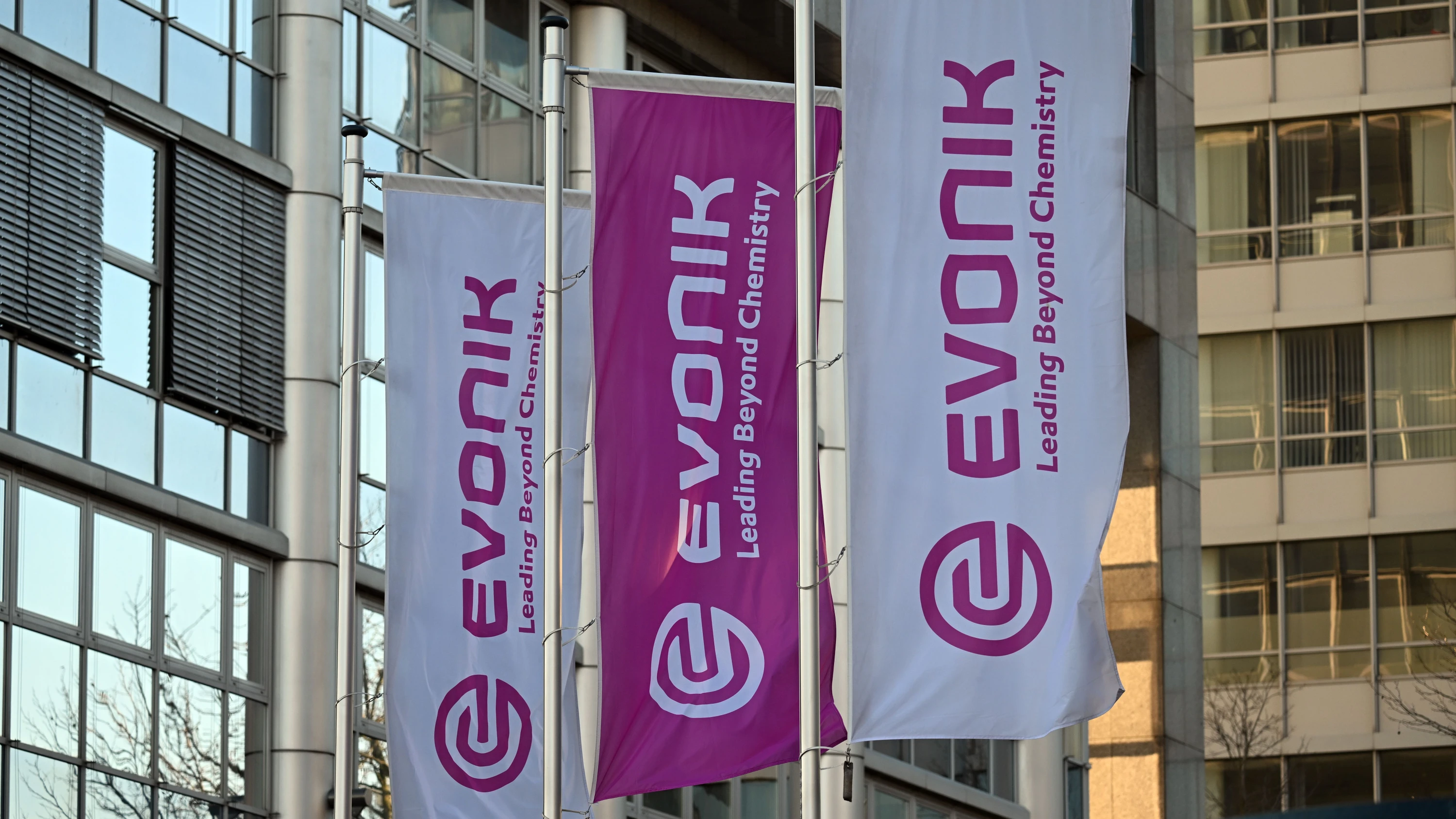 Flaggen mit dem Firmenlogo von Evonik wehen vor der Zentrale des Unternehmens. - dpa