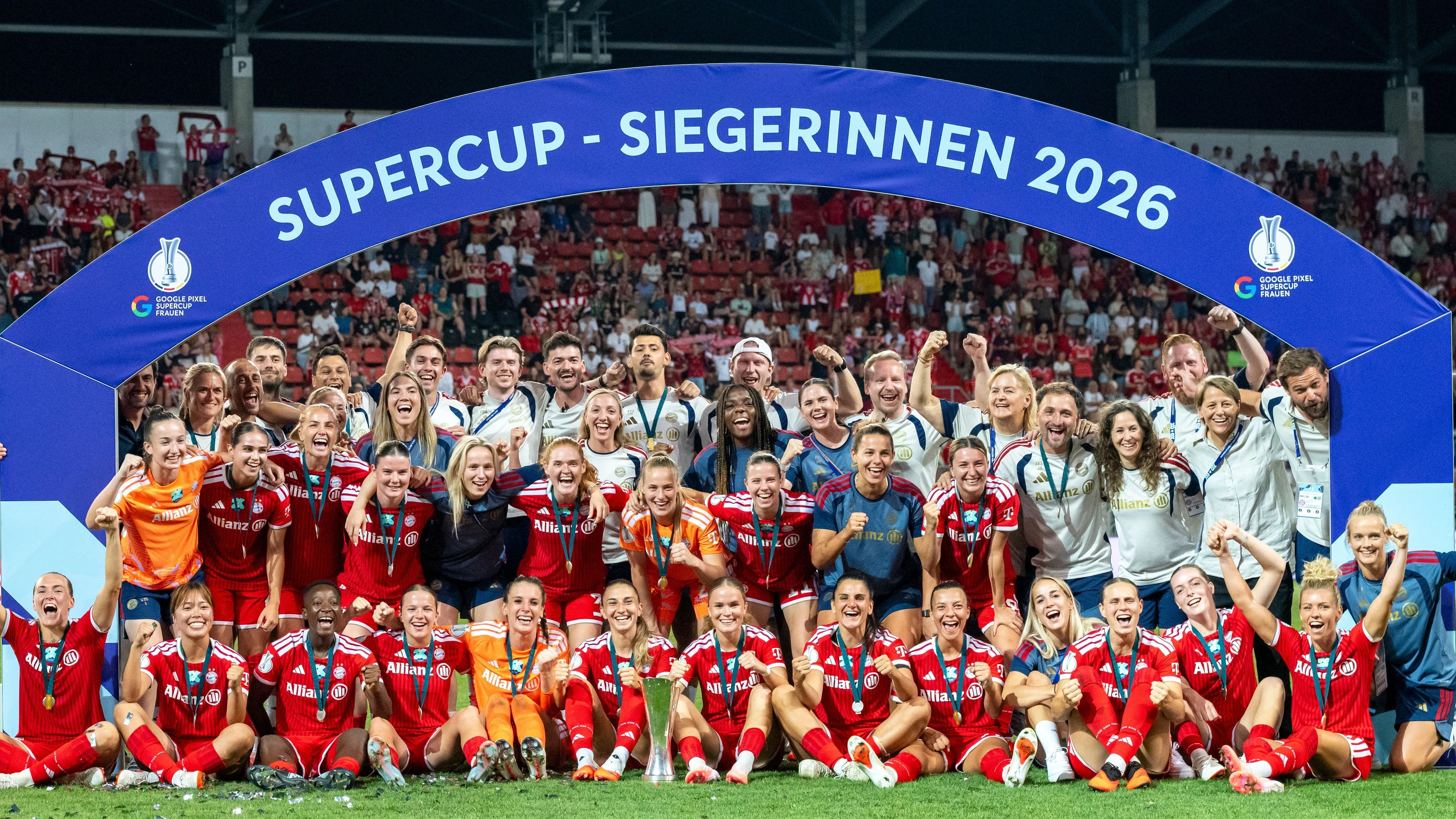 Gruppenbild unter Siegerinnenbogen: Das Team des FC Bayern um Doppeltorschützin Klara Bühl (u. Reihe, 4. v. rechts) feiert den Supercup-Sieg in Ingolstadt. - dpa
