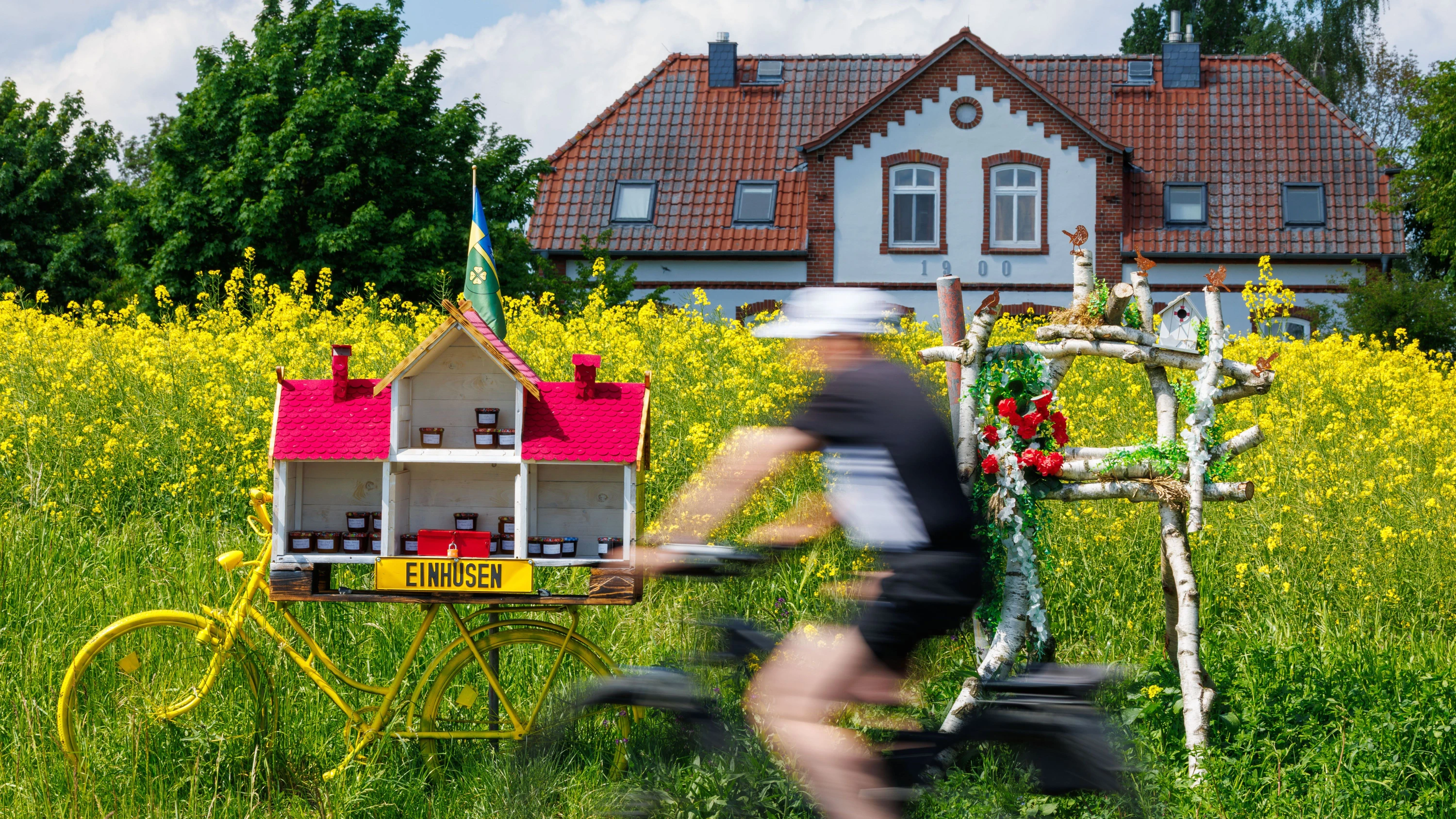 Urlaub auf dem Land: Ein Radler fährt an einem Ferienhaus auf der Ostseeinsel Poel vorbei. - dpa