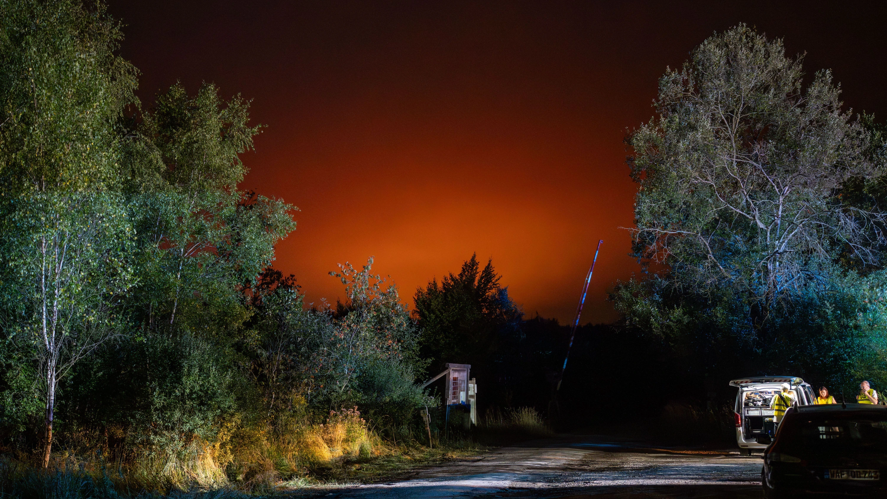 Der Nachthimmel ist rot erleuchtet: Im belgischen Weismes kämpfen Rettungskräfte gegen einen Waldbrand im Hohen Venn. - dpa