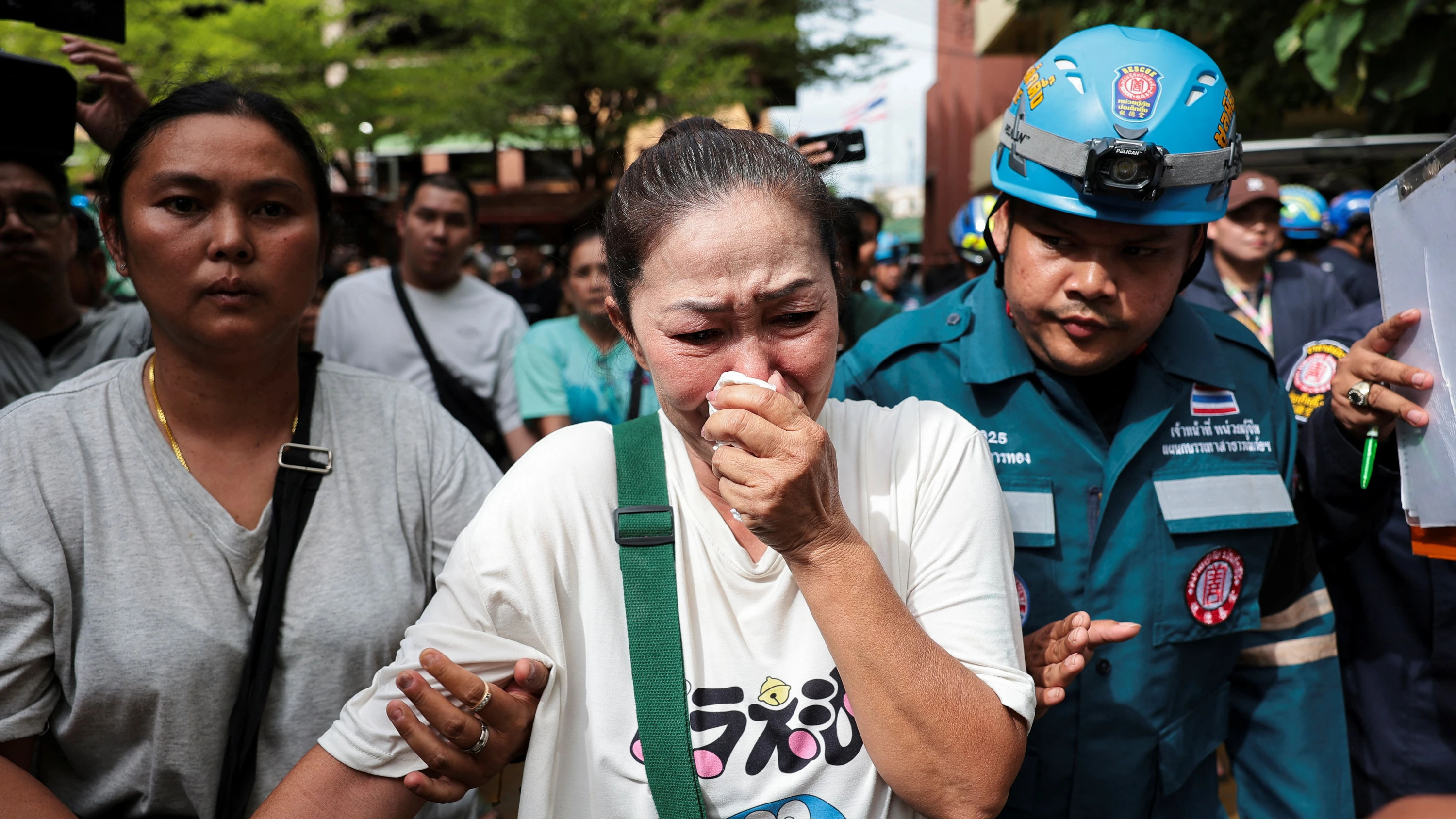 Unter Schock: Angehörige der von einem Vierzehnjährigen erschossenen und verletzten Lehrer der Debsirin-Nonthaburi-Schule in Bangkok werden von Hilfskräften betreut. - Reuters