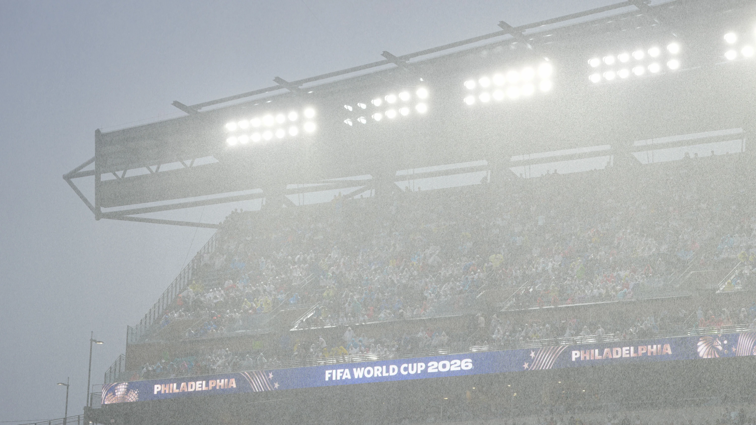 Fans verfolgen bei Regen das Fußballspiel zwischen Frankreich und dem Irak. - dpa