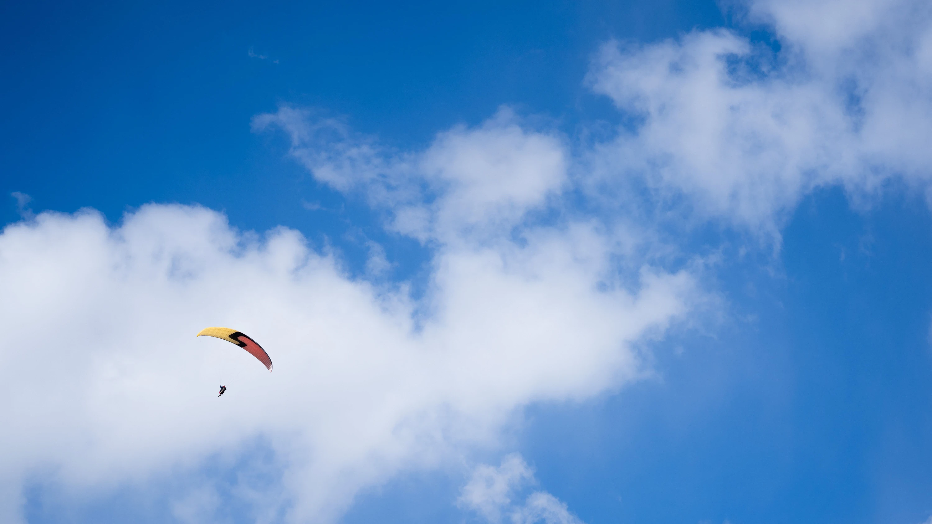 Ein Paraglider gleitet bei teilweise blauem Himmel durch die Luft. (Symbolbild) - dpa