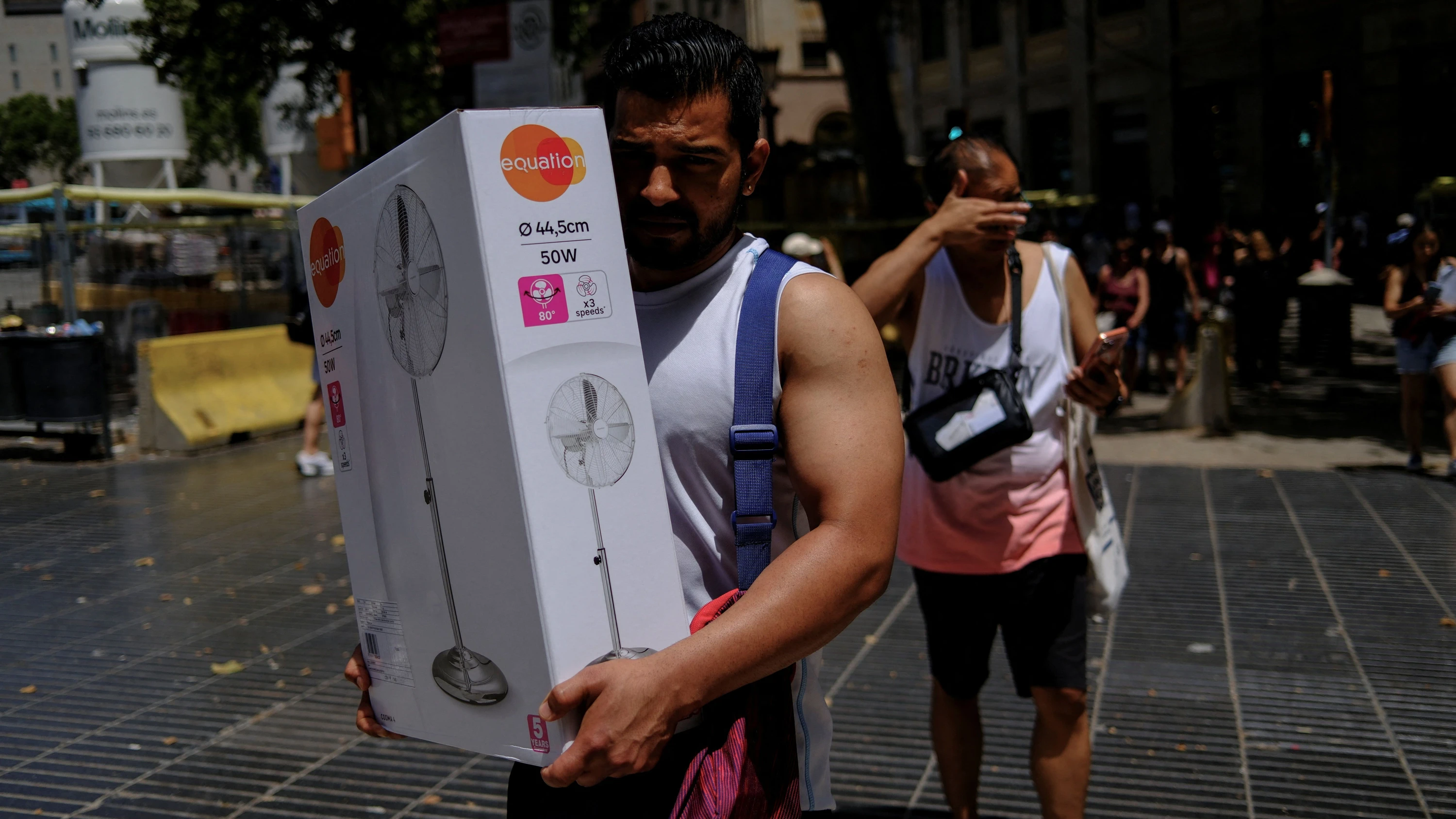 Barcelona am 21. Juni: Ein Mann trägt einen gerade gekauften Ventilator durch die Sonne. - Reuters