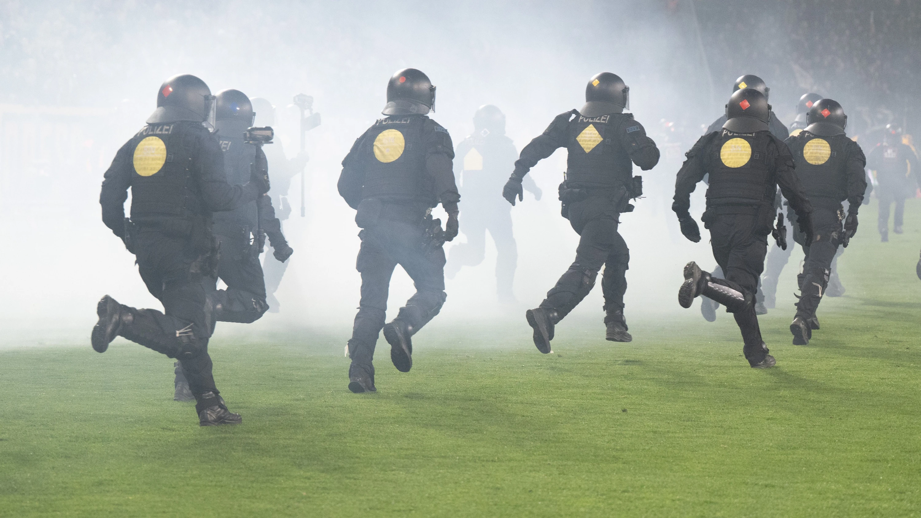 Polizisten laufen im Dresdner Stadion nach Ausbruch der Gewalt über den Rasen. - dpa