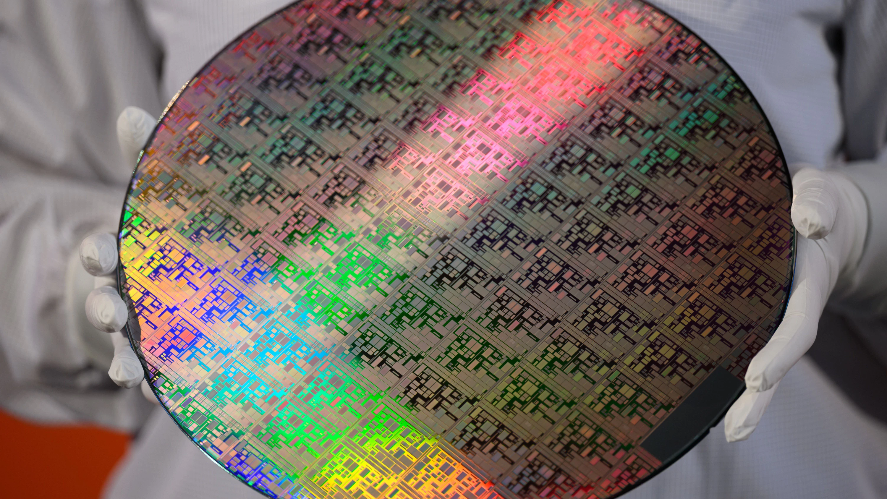 Eine Mitarbeiterin des Chipherstellers Global Foundries hält einen 300-Millimeter-Wafer. - Picture Alliance