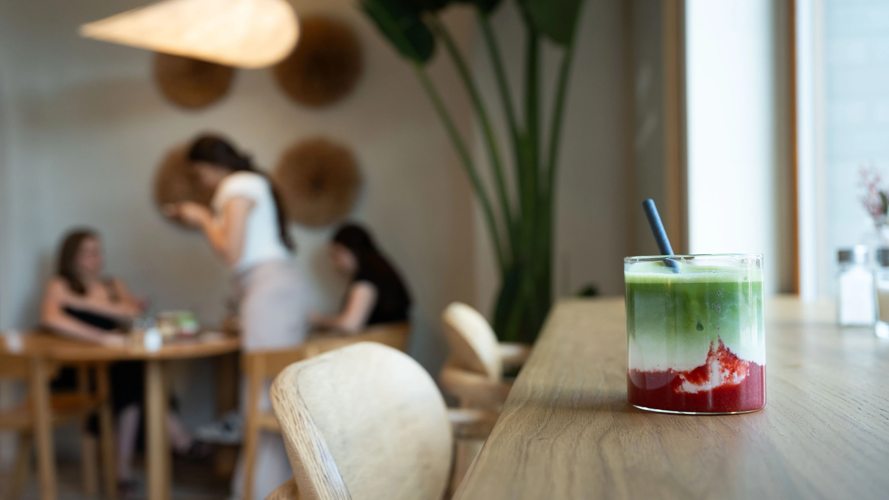 Aufnahme eines Strawberry Iced Matcha Latte auf einem Tisch des Cafés Lagóm im Europaviertel. - Stefan Nieland