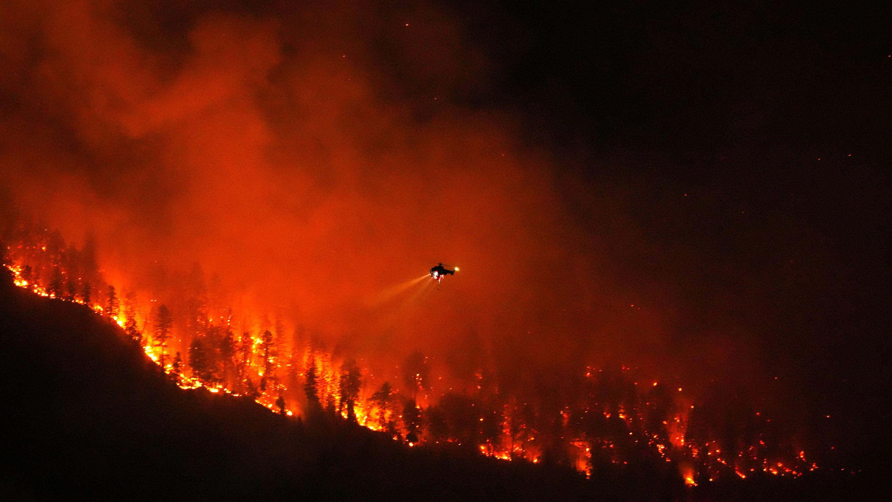 Ein Hubschrauber wirft bei einem Nachtflug Wasser auf den Waldbrand am Quilpituk Creek auf der Westseite des Okanagan-Sees in British Columbia ab. - dpa