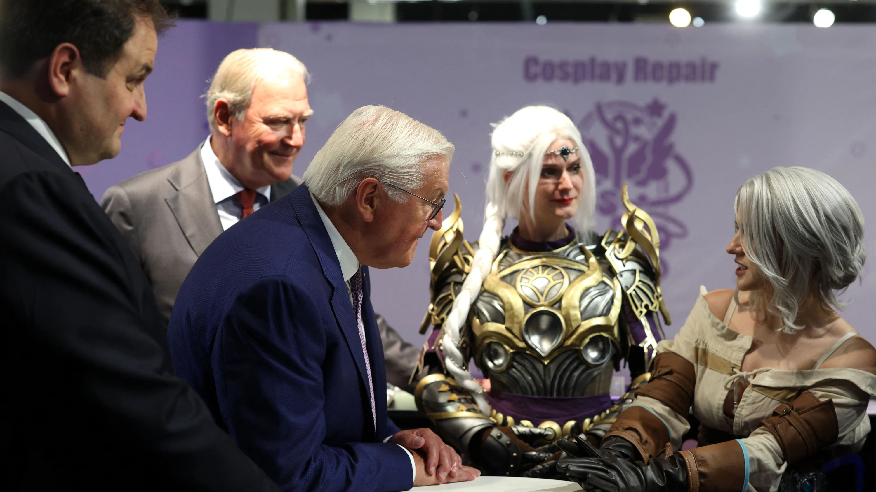 Frank-Walter Steinmeier (Mitte) im Gespräch mit einer Cosplayerin, die als Ciri aus „The Witcher“ verkleidet ist - dpa