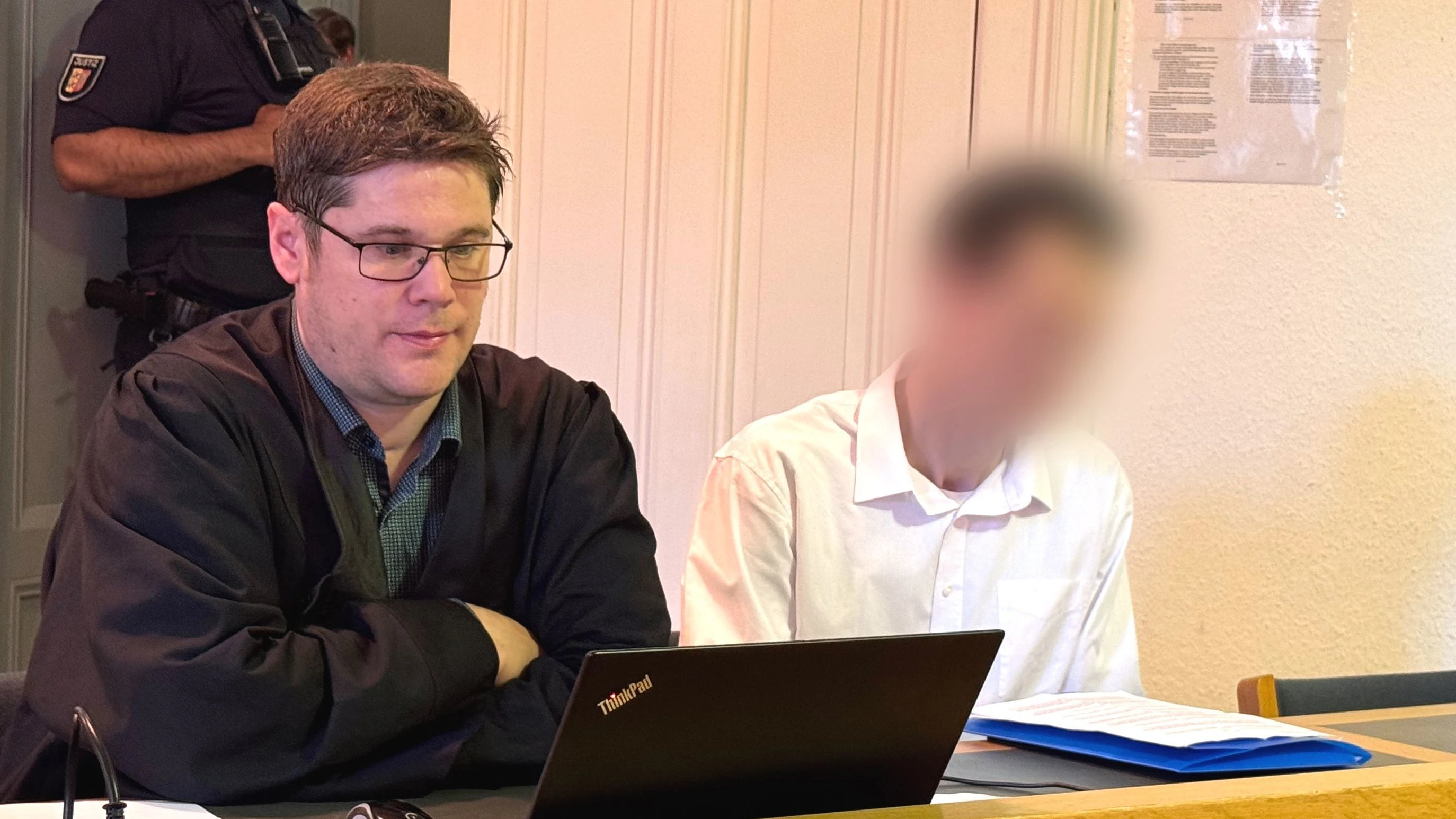 Der Angeklagte (r) sitzt neben seinem Anwalt, Patrick Schlicker, im Amtsgericht. Der 38-Jährige soll im vergangenen Jahr einen kleinen Hund in Flensburg an einen Baum gehängt und damit getötet haben. - dpa