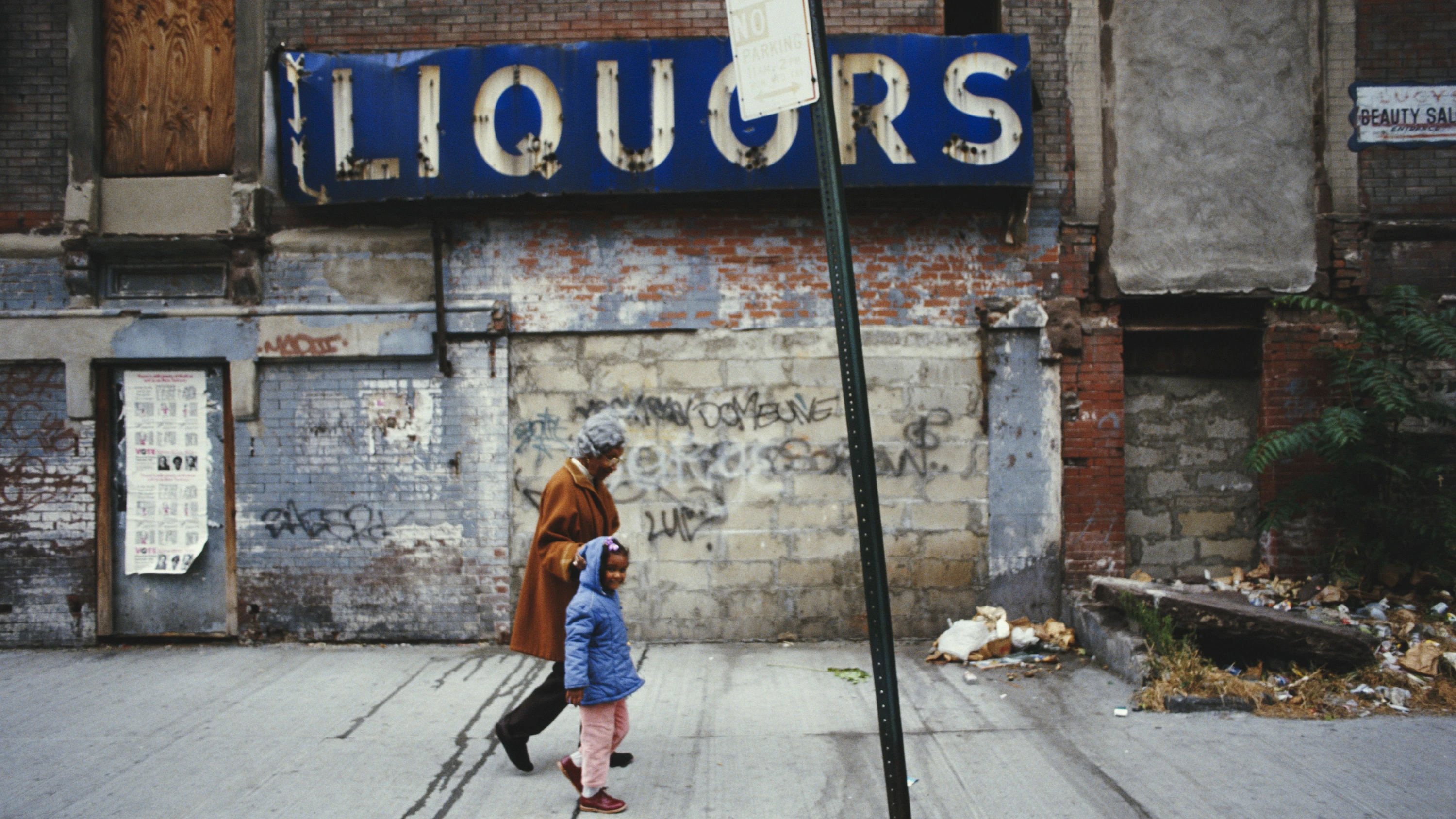 Die Zahnräder anhalten? Kaum. Aber versuchen, nicht dazwischen zu geraten: Straßenszene mit der Wohltäterin „Mother Hale“ und einem Kind in Harlem, 1986 - Getty Images