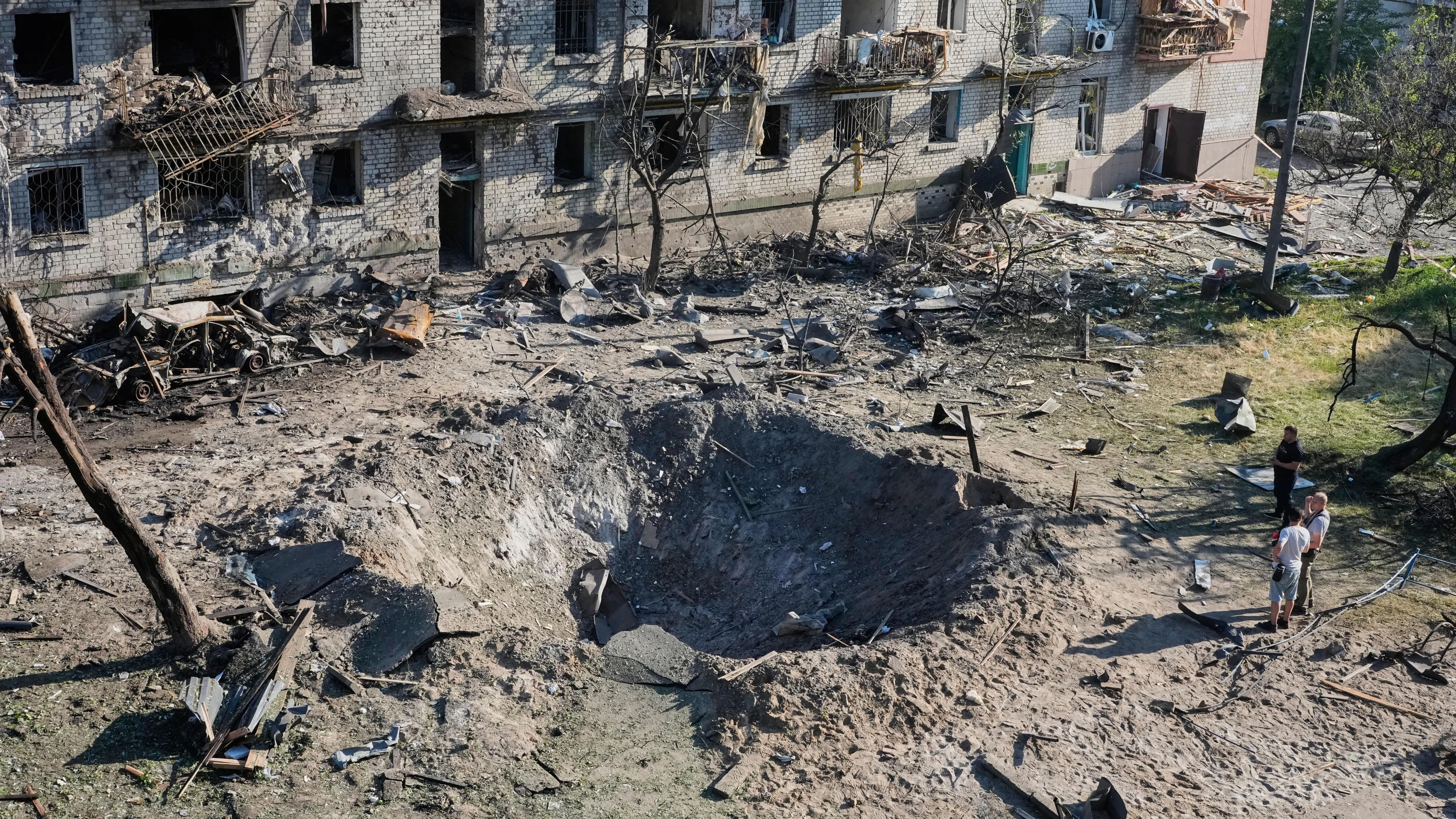 Anwohner betrachten die Stelle eines russischen Raketenangriffs, der in der Nacht auf Donnerstag ein Wohnhaus in Kiew getroffen hat. - dpa