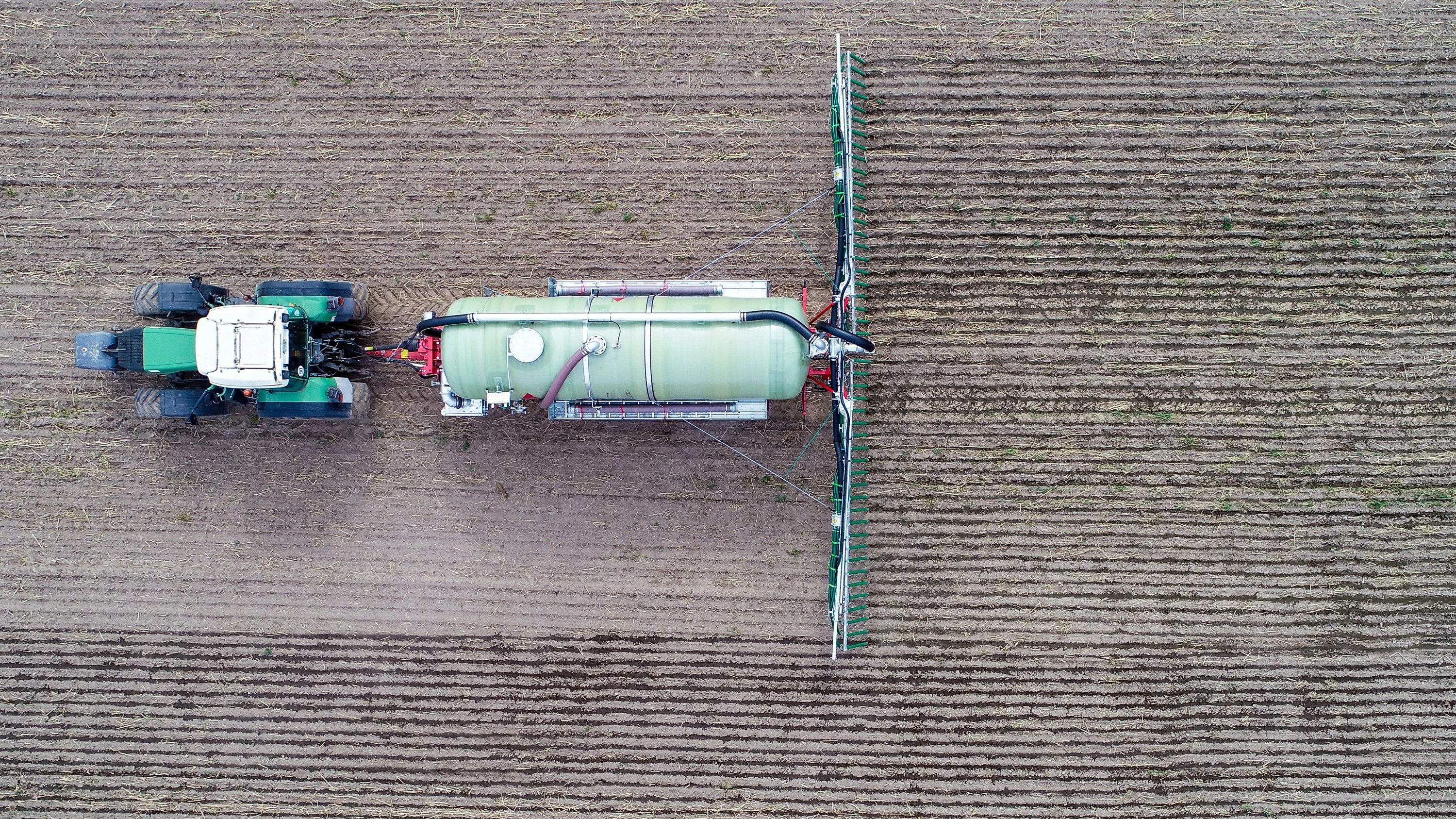 Ein Landwirt in Brandenburg düngt ein Feld. - dpa