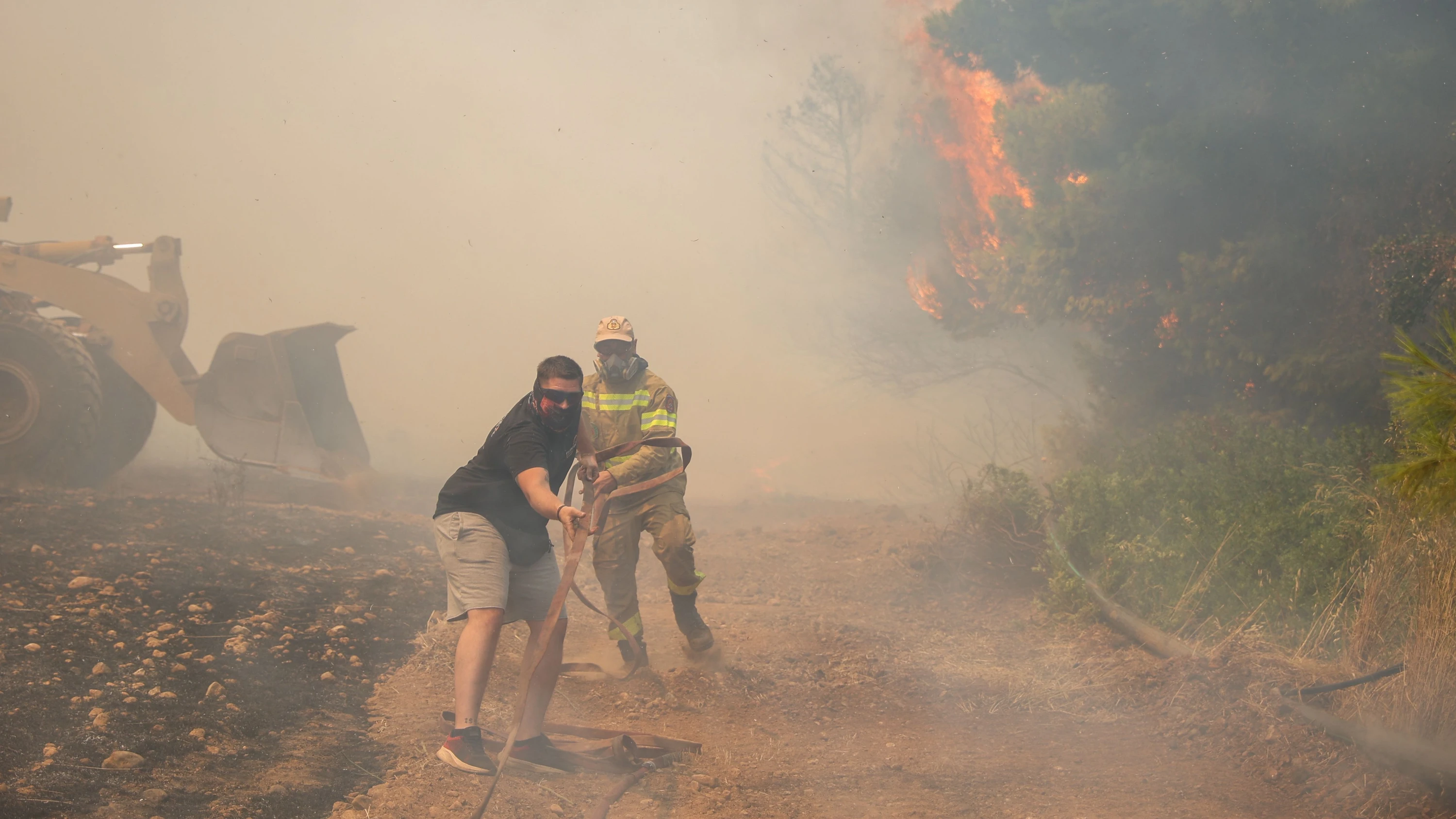 Freiwillige und Feuerwehrleute versuchen, die Feuer in Griechenland einzudämmen. - AFP
