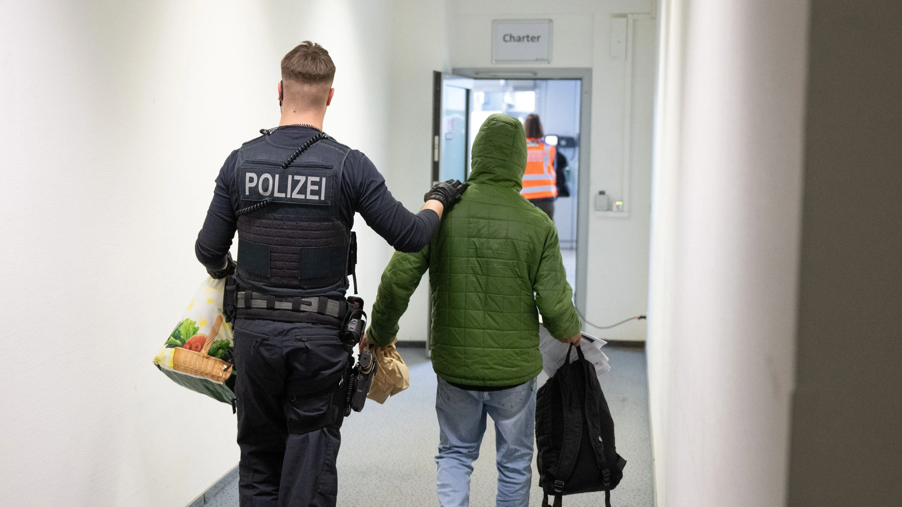 Abgang: Ein Polizeibeamter bringt einen Mann zu einem Abschiebeflug nach Pakistan. - dpa