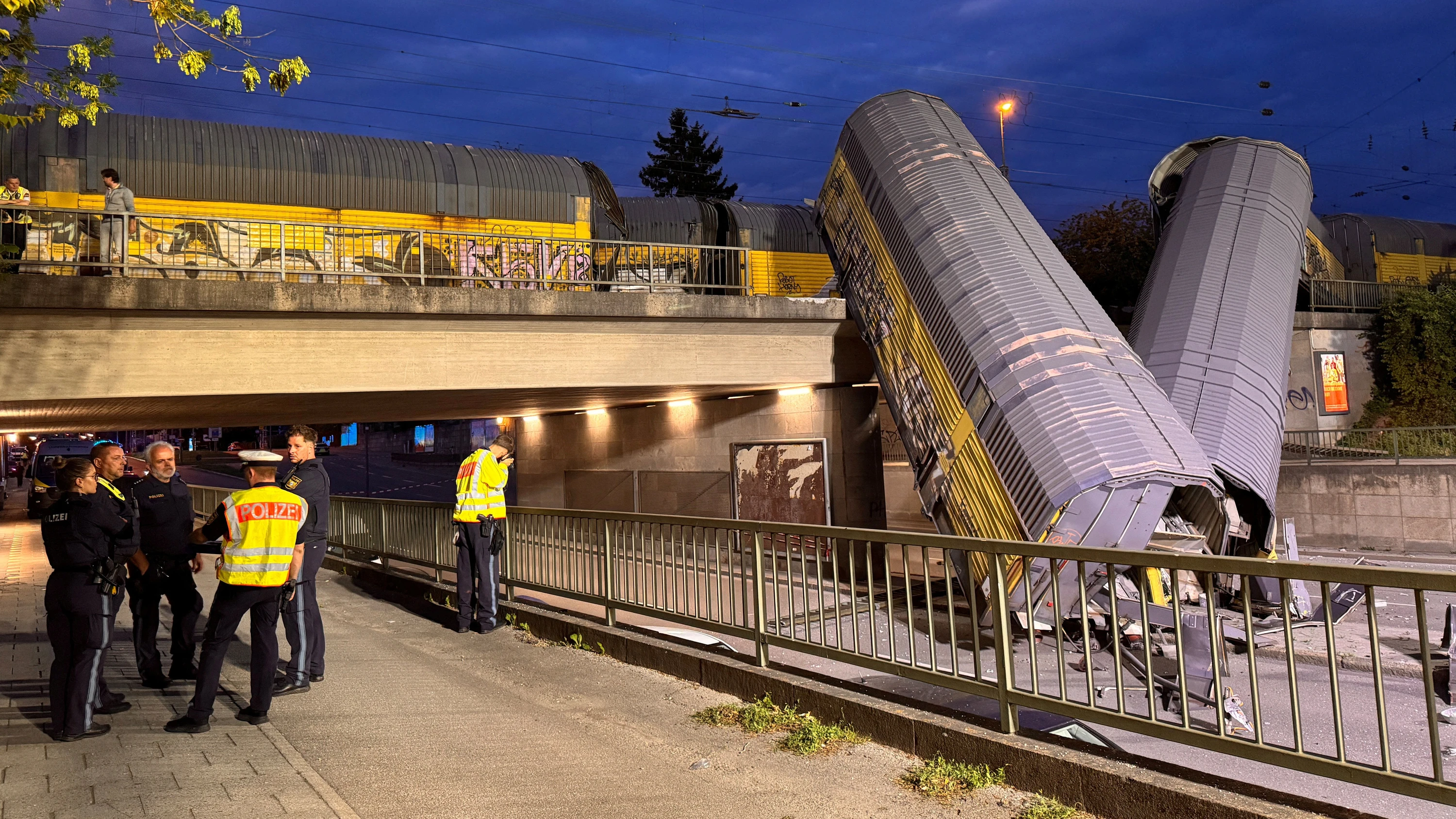 Zwei Waggons eines Güterzugs liegen auf einer Straße, nachdem sie von einer Brücke in München gestürzt sind. - Reuters