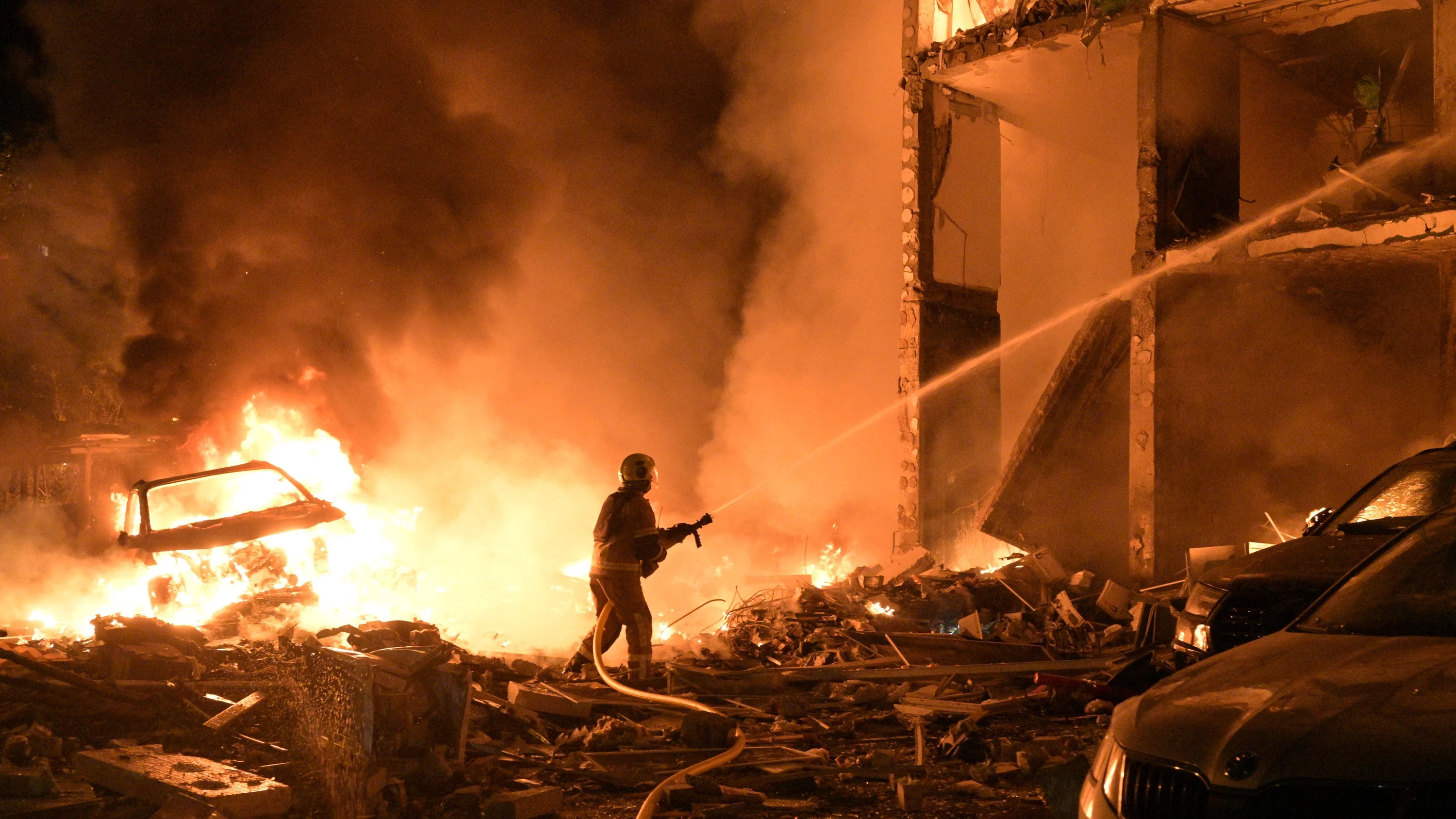 Löscharbeiten in Kiew: Ein Gebäude und ein Fahrzeug stehen nach den Einschlägen in Flammen. - dpa