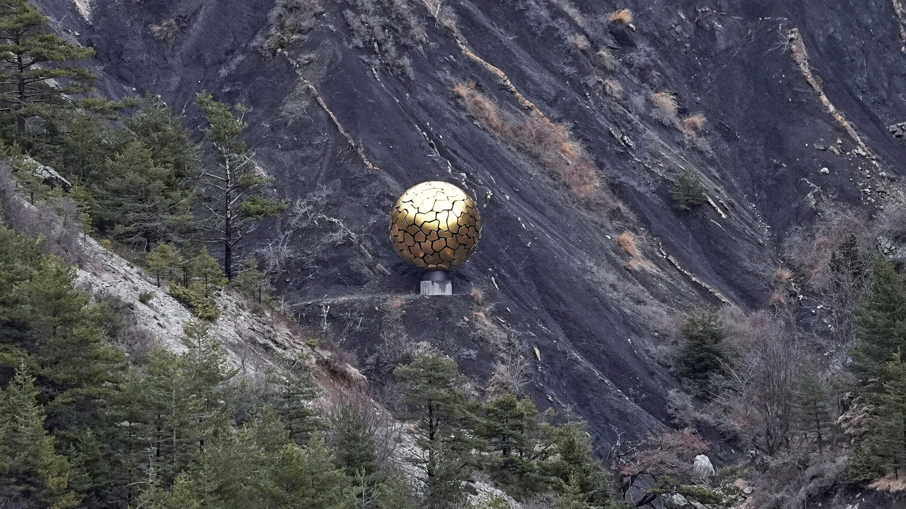 Eine fünf Meter große goldene Sonnenkugel ist an der Absturzstelle des Germanwings-Flugzeugs in der Nähe von Le Vernet in den französischen Alpen zu sehen. - dpa