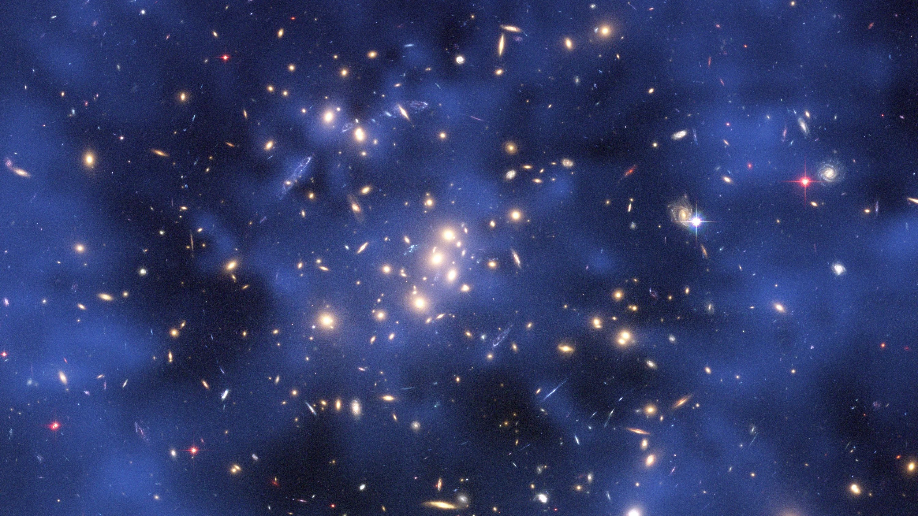 Ein Ring Dunkler Materie (blaue Struktur) umhüllt einen Galaxienhaufen. Die Verteilung der Dunklen Materie wurde am Computer anhand von Modellen errechnet und dann über ein Foto des Hubble-Weltraumteleskops gelegt. - dpa