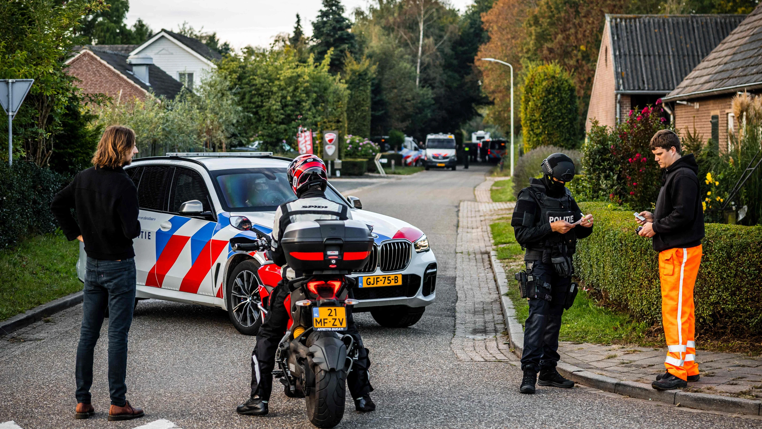 Ein Polizeifahrzeug blockiert unweit des Tatorts in Overasselt die Straße. - AFP