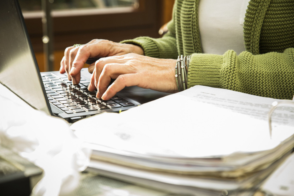 ILLUSTRATION - Eine Rentnerin sitzt am 09.11.2022 in Winsen/Luhe an ihrem Schreibtisch und sortiert Belege (gestellte Szene). Foto: Christin Klose