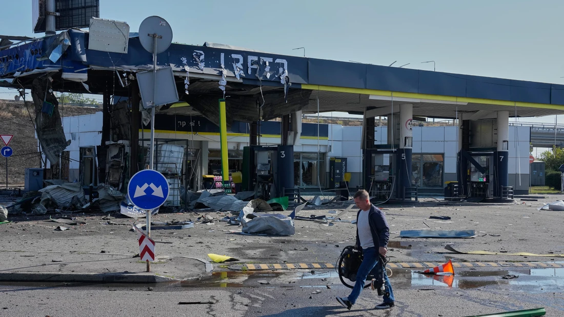 Ein Mitarbeiter verlässt die beschädigte Tankstelle nach einem russischen Drohnenangriff in Kiew.