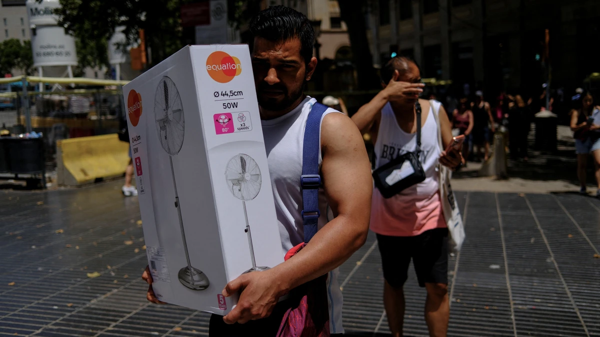 Barcelona am 21. Juni: Ein Mann trägt einen gerade gekauften Ventilator durch die Sonne.