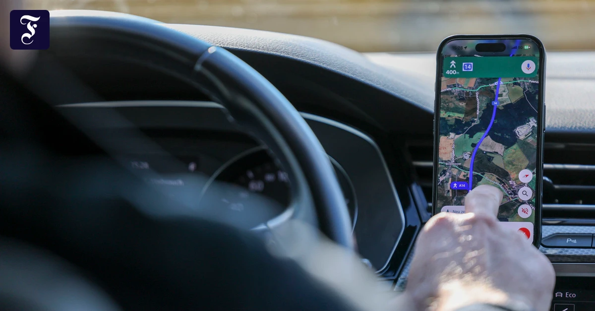 Ein Mann sucht im Auto ein Ziel in Google Maps auf einem Smartphone. (Ảnh: FAZ.NET)