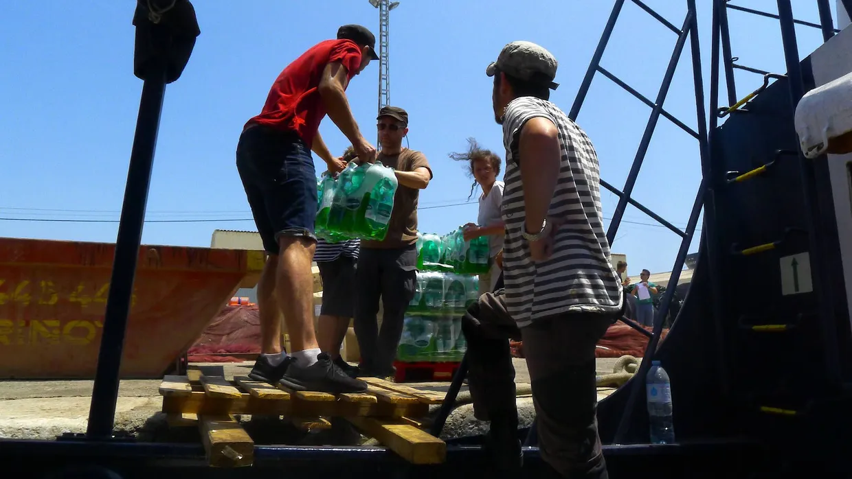 Die Crew verstaut Wasservorräte an Deck der „Alan Kurdi“.