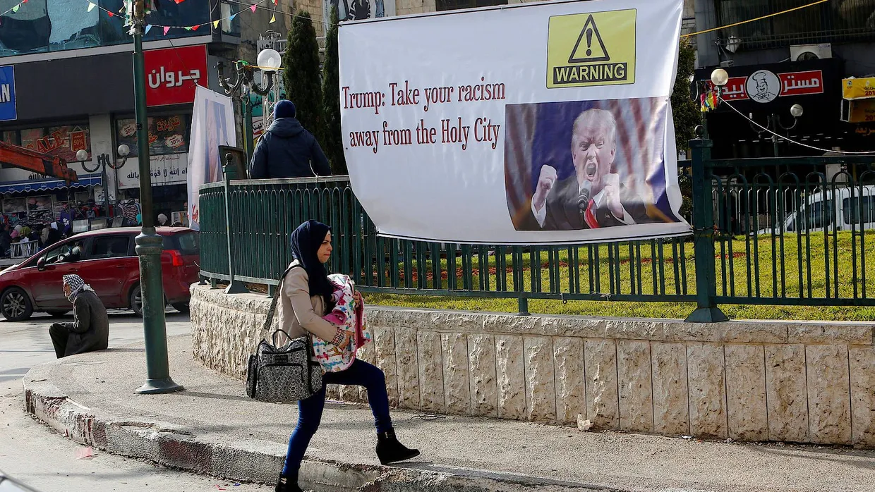 Eine Palästinenserin läuft in Nablus an einem Banner vorbei, das gegen Donald Trumps Ankündigung protestiert, die amerikanische Botschaft nach Jerusalem zu verlegen.
