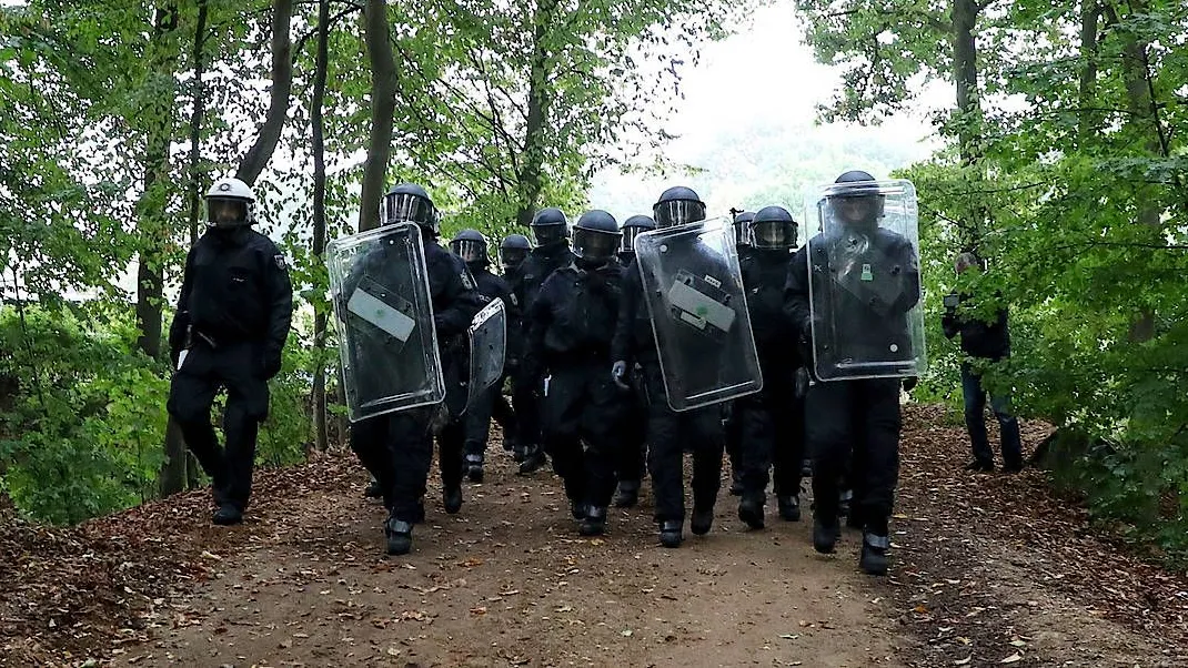 Die Idylle Hambacher Forst trügt: Polizisten bringen sich am Donnerstag im Hambacher Forst in Stellung, um die Räumung der Umweltaktivisten-Camps zu vollziehen.
