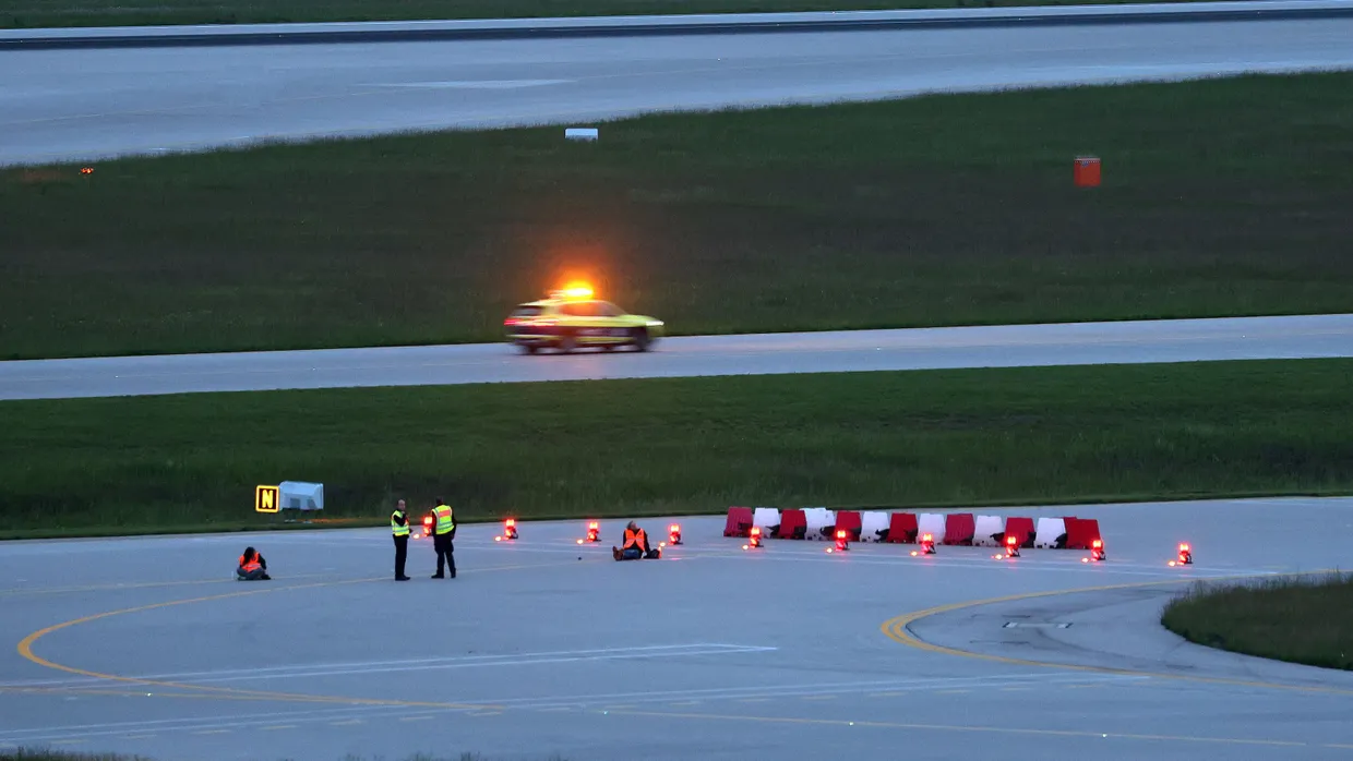 Klimaaktivisten haben sich am frühen Morgen auf einer Zufahrt für Start- und Landebahnen am Flughafen Franz-Josef-Strauß festgeklebt.