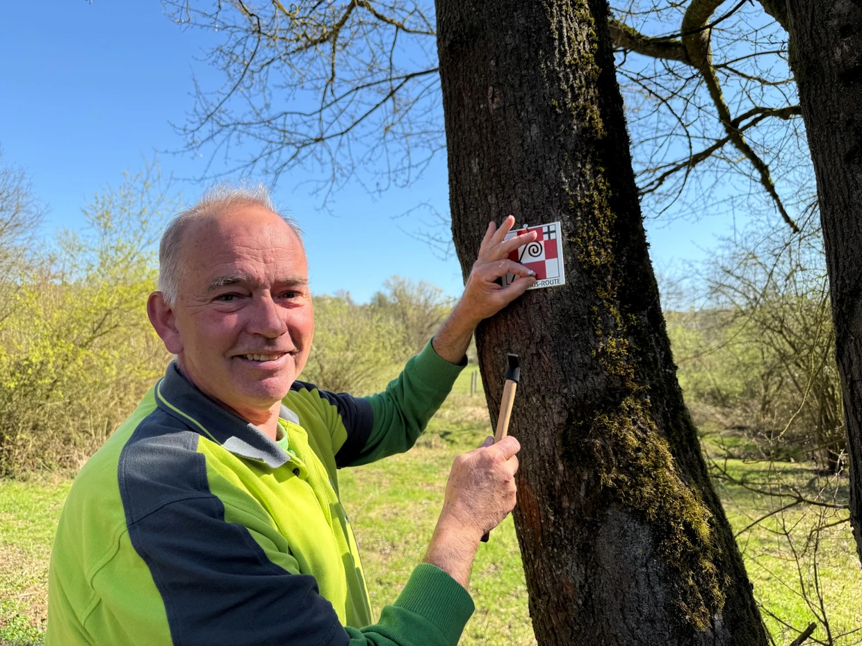 Wegewart Peter Lill-Hendriks bringt entlang der Bonifatius-Route Hinweisschilder an.