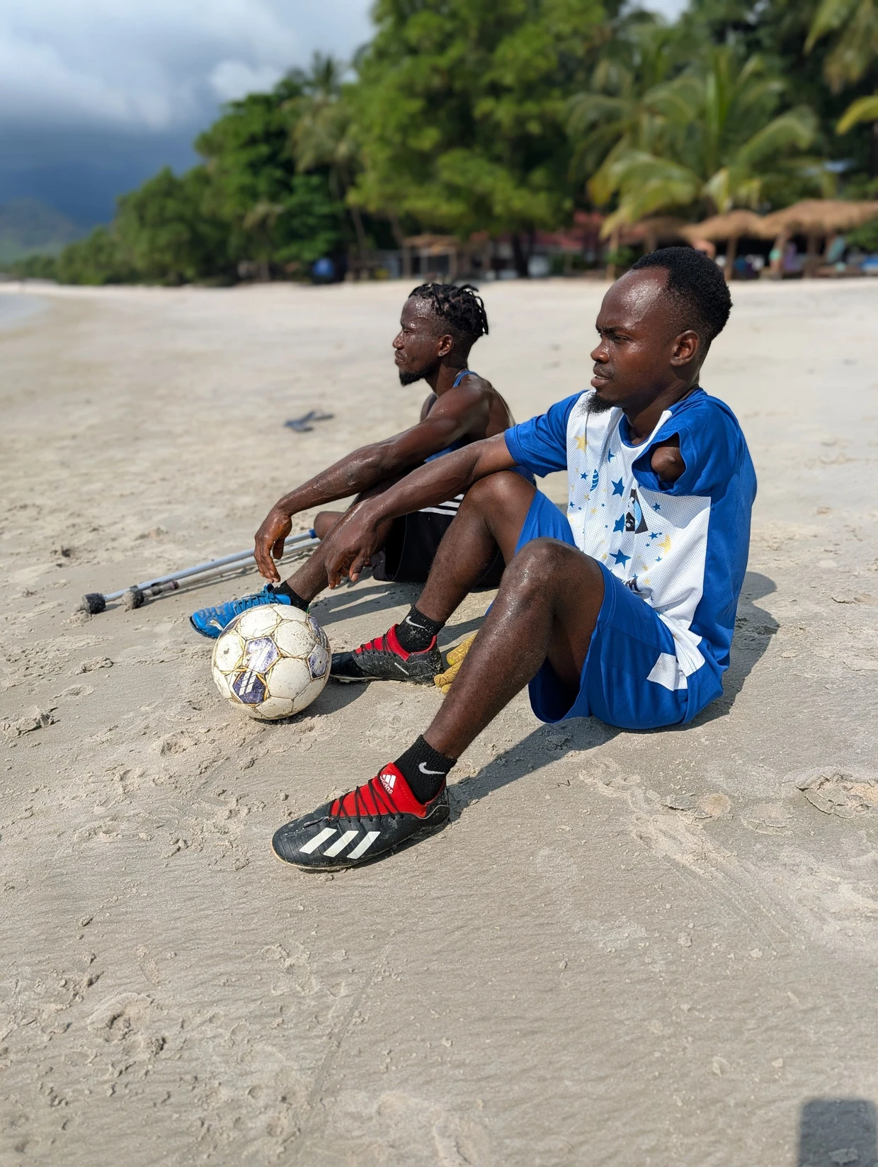 Break on Tokeh Beach: Bassie and Kamara sit on the field.