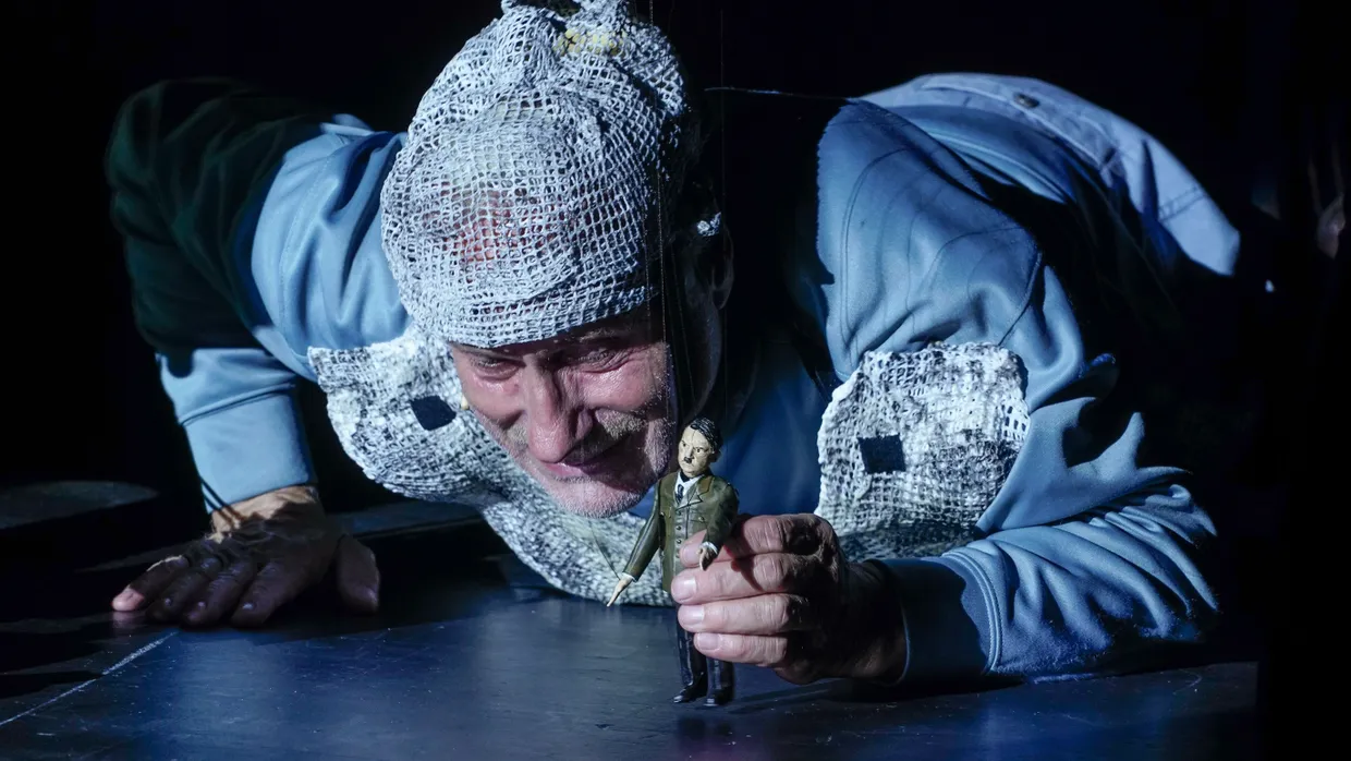 Schwejk (Wolfram Koch) mit Miniatur-Hitler