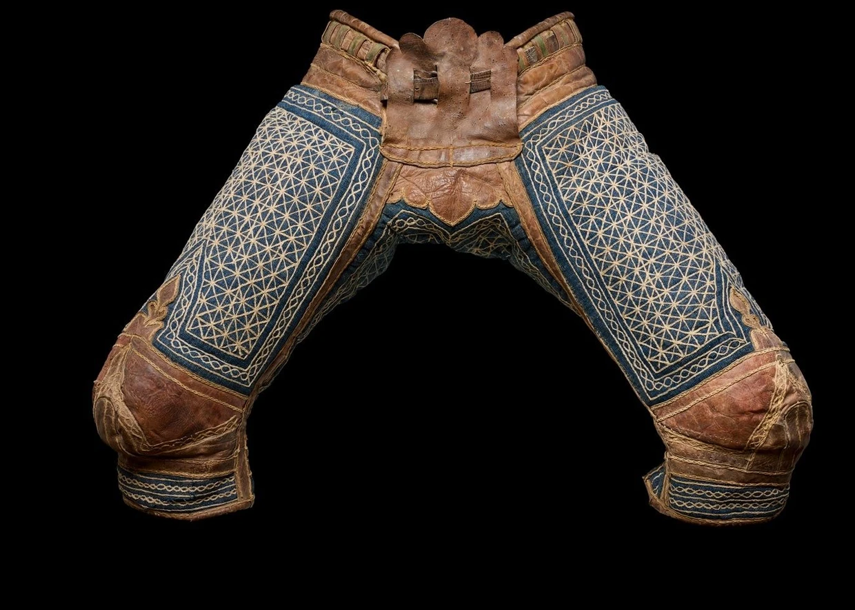  Rinds- und Schafleder, Baumwollstoff mit Steppnähten und Wattierung aus Tierhaar plus Metallschnalle