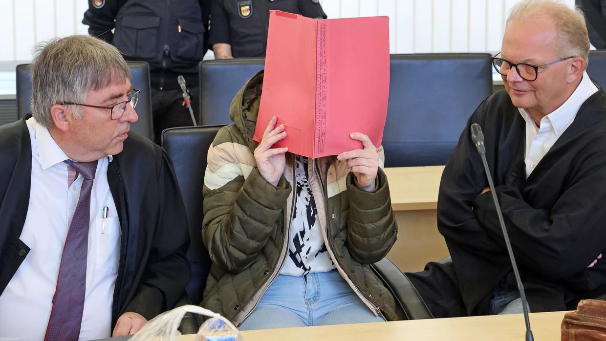 Die Angeklagte sitzt am Dienstag zwischen ihren beiden Anwälten und verdeckt ihr Gesicht.