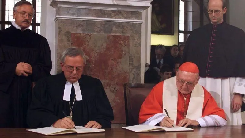 Der Präsident des Lutherischen Weltbundes, Bischof Christian Krause, und der Präsident des päpstlichen Einheitsrates, Kardinal Edward Cassidy, unterzeichnen am 31. Oktober 1999 in Augsburg die „Gemeinsame Offizielle Feststellung zur Rechtfertigungslehre Luthers“, durch die die im 16. Jahrhundert gegenseitig ausgesprochenen Lehrverurteilungen aufgehoben werden.