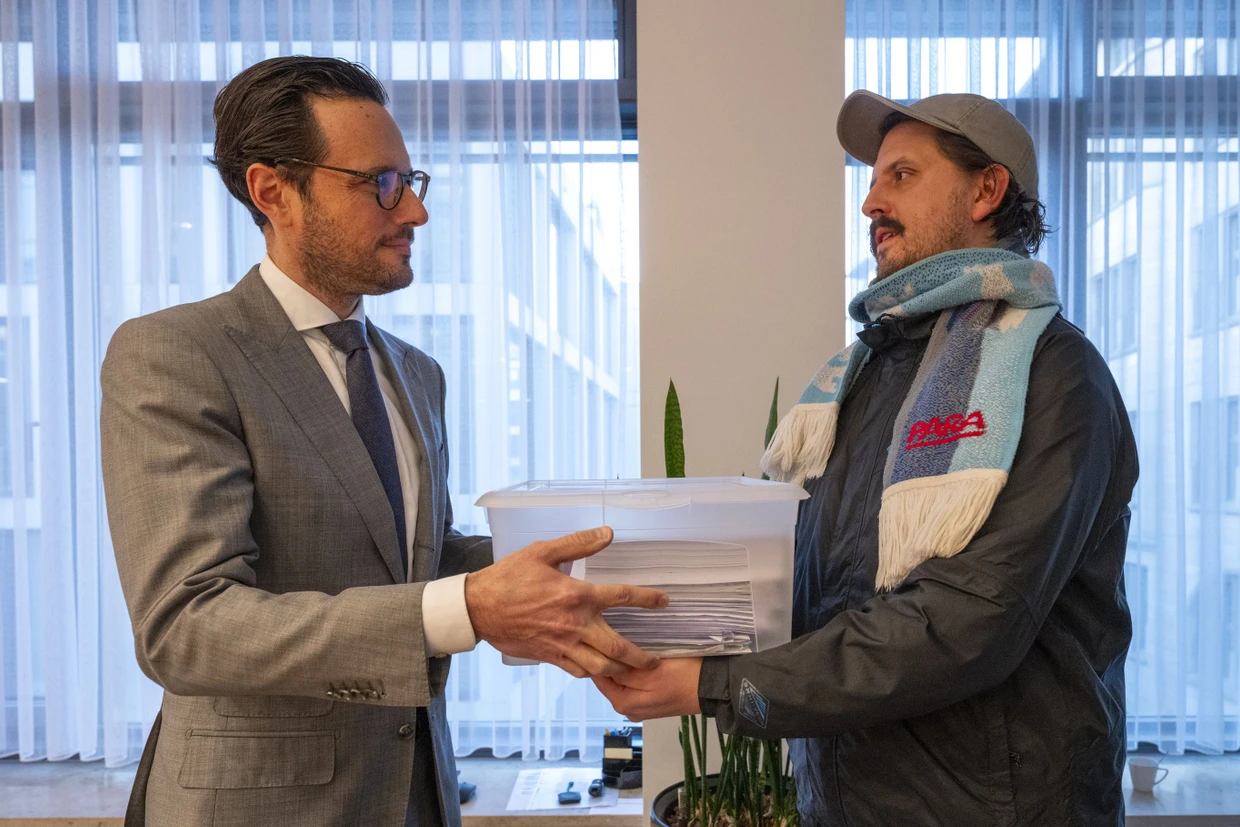 Bastian Sistig (rechts) übergibt Bürgermeister Fabian Mayer die gesammelten Unterschriften.