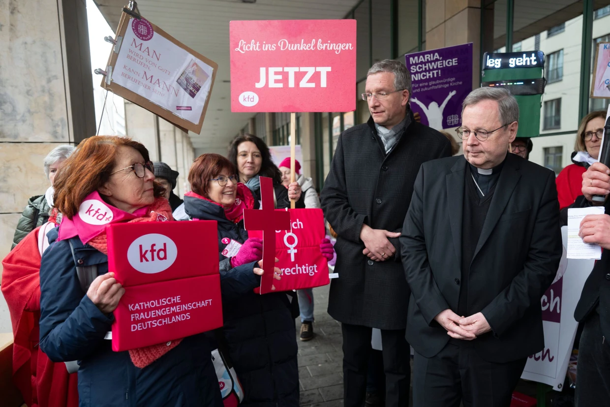 The chairman of the German Bishops' Conference Georg Bätzing (right) and Bishop Michael Gerber meet demonstrators on Thursday in Stuttgart