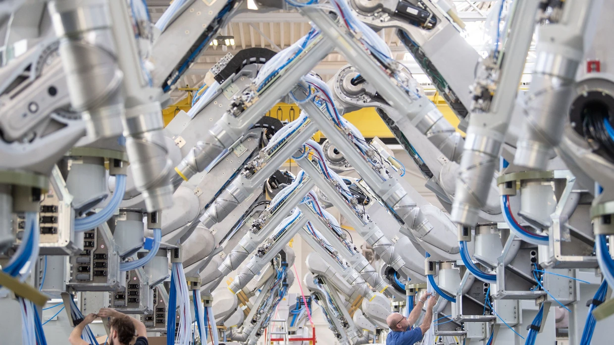 Mitarbeiter der Dürr AG montieren Lackierroboter.