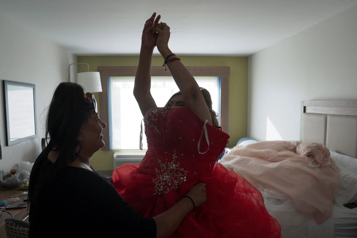 Marlén Vázquez ayuda a Dilian Quijano, de 58 años, a ponerse su vestido de fiesta.