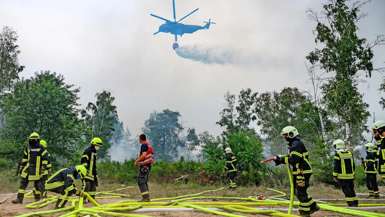 Höchstleistung: Löschhubschrauber der Bundeswehr und die Feuerwehr bekämpfen den Brand in der Gohrischheide zwischen Sachsen und Brandenburg.