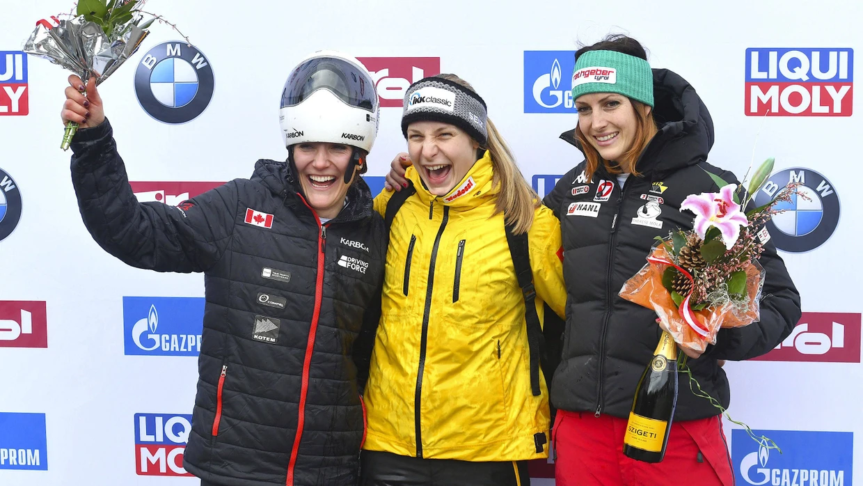 Die Gewinnerin Tina Hermann (Mitte) die Zweitplatzierten Mirela Rahneva (links) und die Drittplatzierte Janine Flock (rechts) jubeln bei der Siegerehrung auf dem Podest.