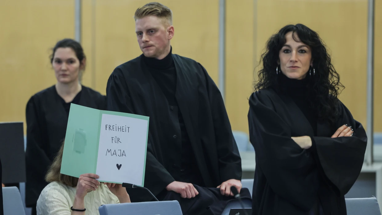 Eine der Angeklagten verbirgt beim Prozessbeginn im Januar 2026 im Düsseldorfer Sitzungssaal ihr Gesicht und sendet eine Botschaft.