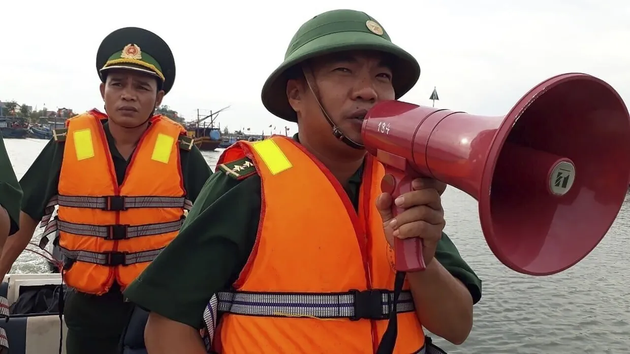 Ein Offizier der Küstenwache spricht in der Quang Binh Provinz in Vietnam durch ein Megafon.