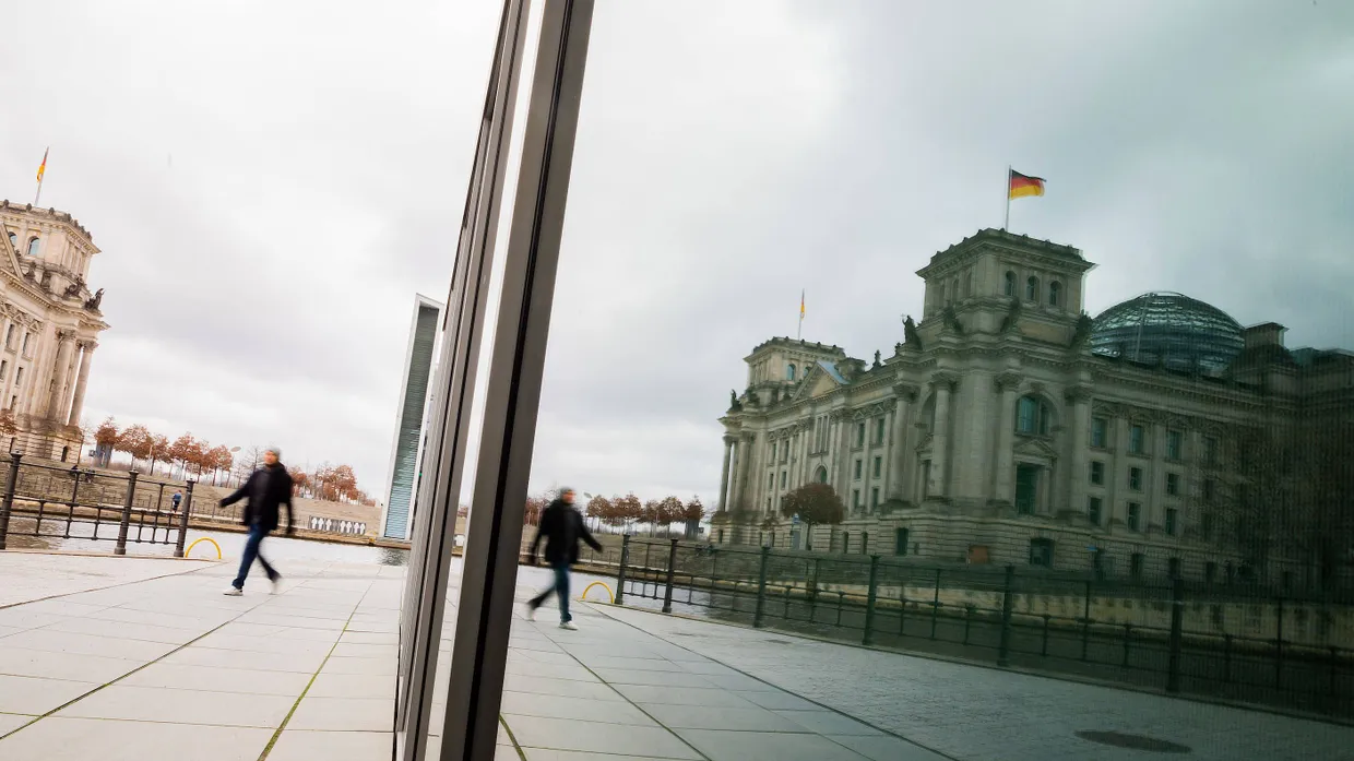 Ein Passant läuft am Berliner Reichstagsgebäude vorbei.