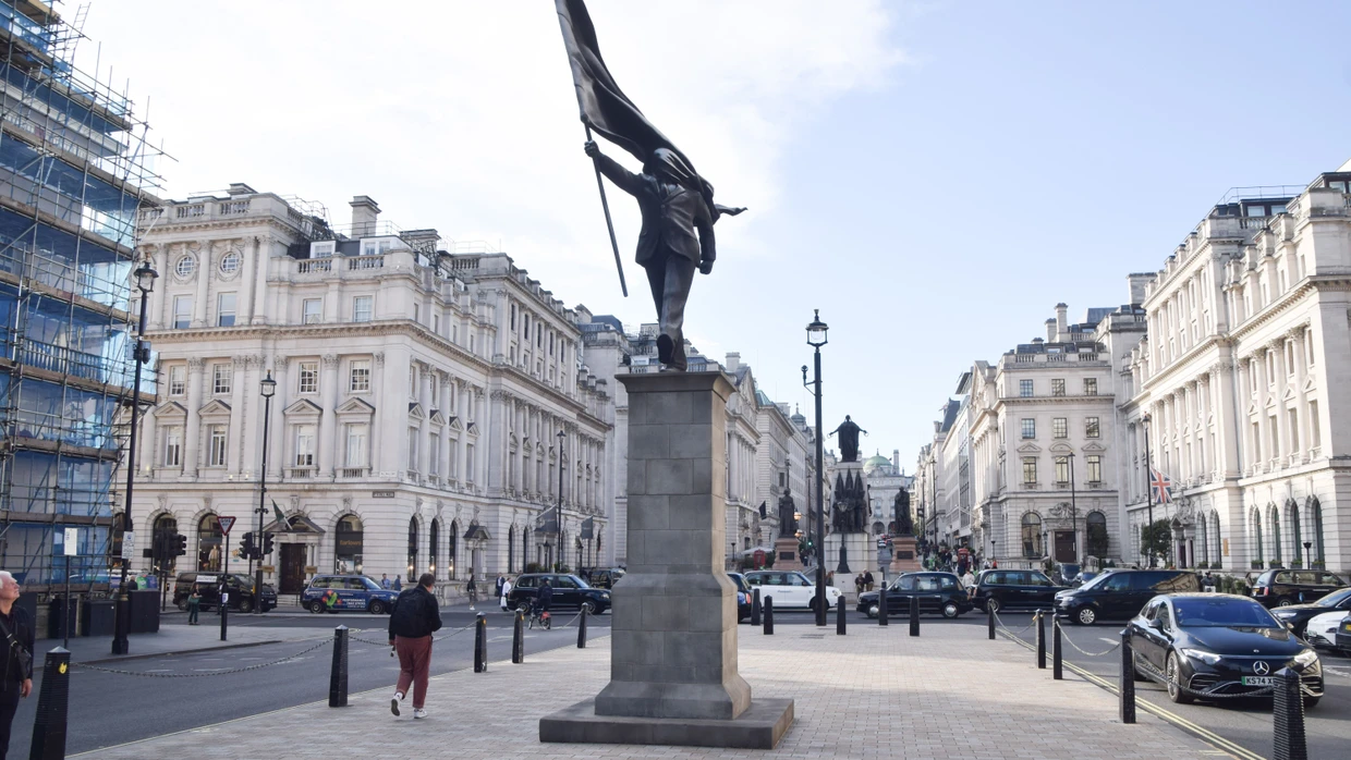 There is a statue in Waterloo Place in central London that shows a man holding a flag that obscures his face and has the signature 
