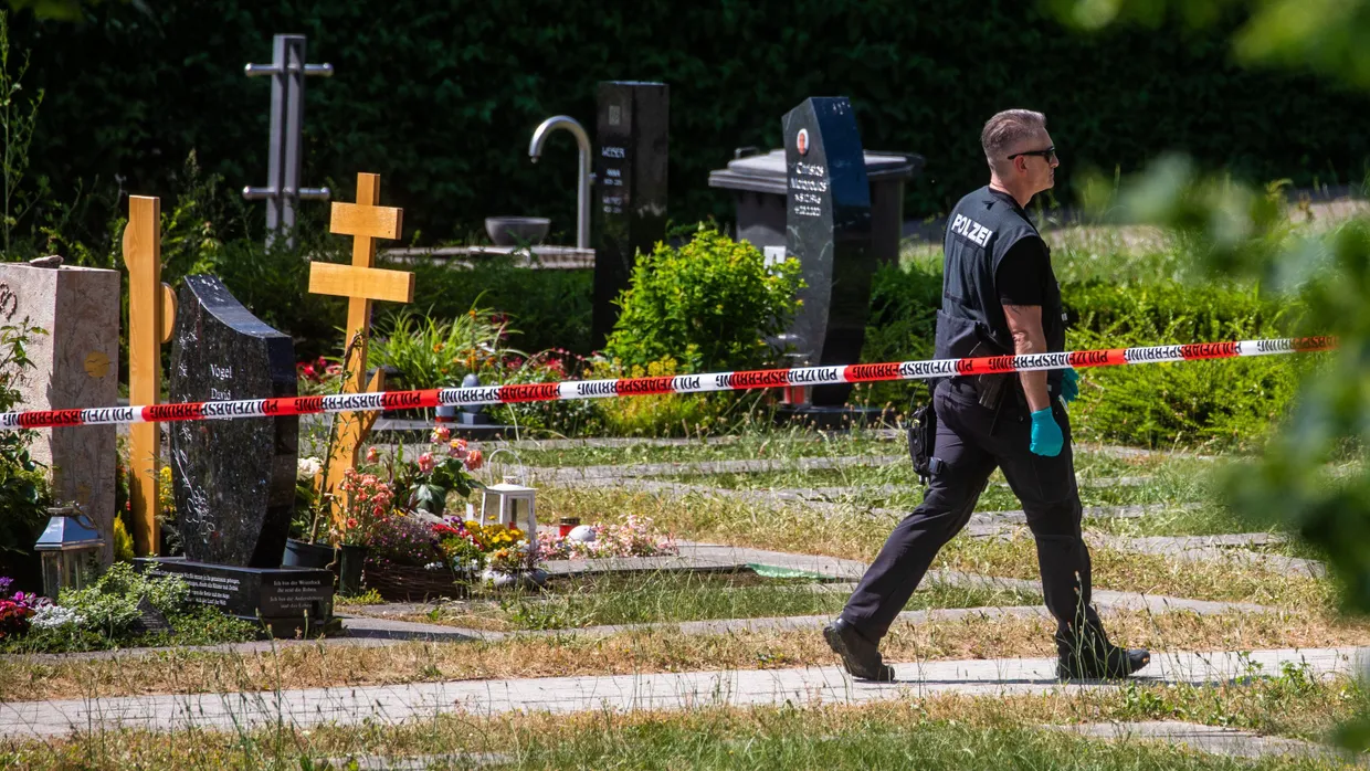 Ein Polizist läuft über den abgesperrten Teil des Friedhofs in Altbach.