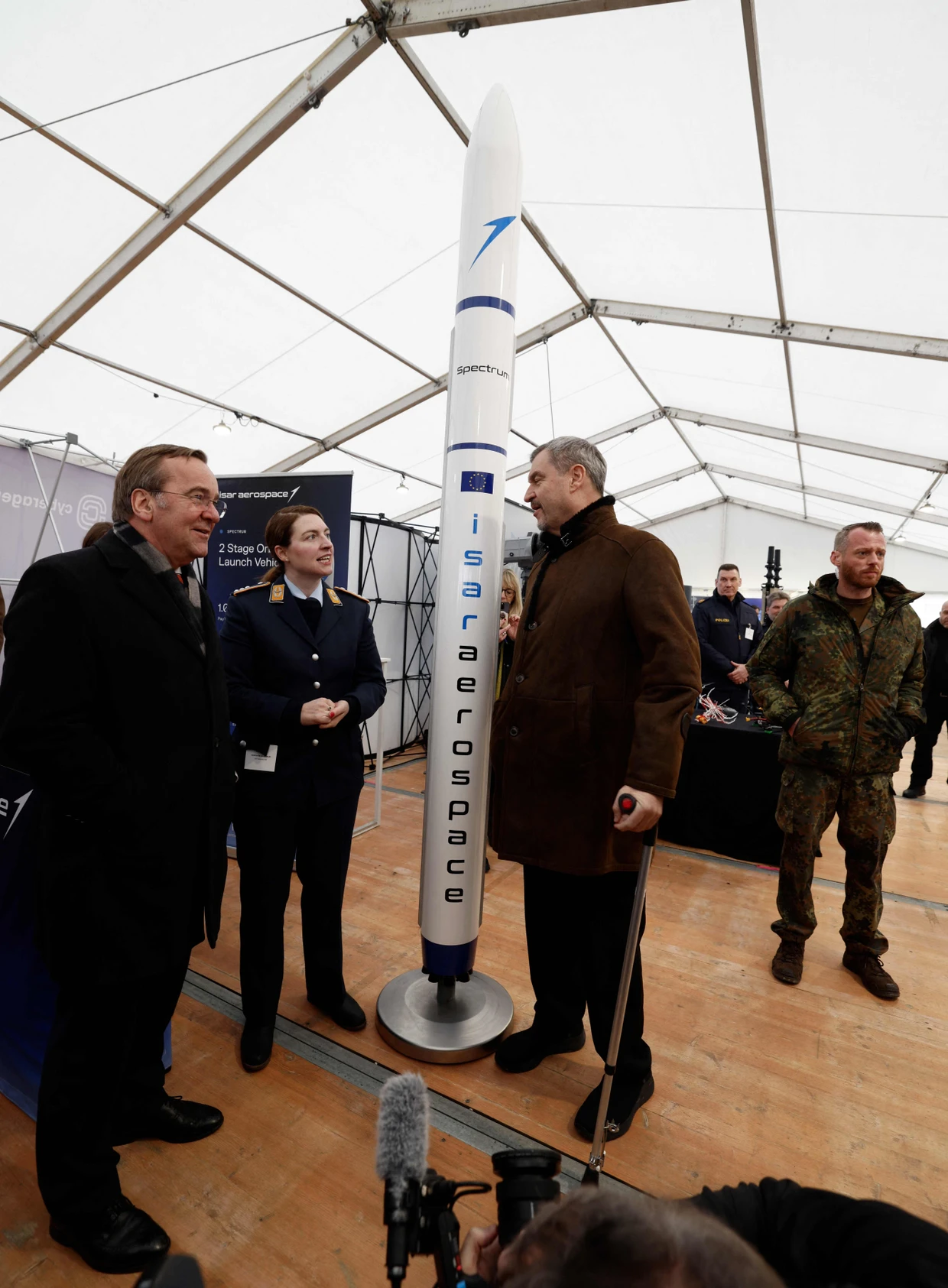 Bundesverteidigungsminister Boris Pistorius (links) und der bayerische Ministerpräsident Markus Söder (dritter von links) neben dem Modell einer Rakete des deutschen Start-ups Isar Aerospace